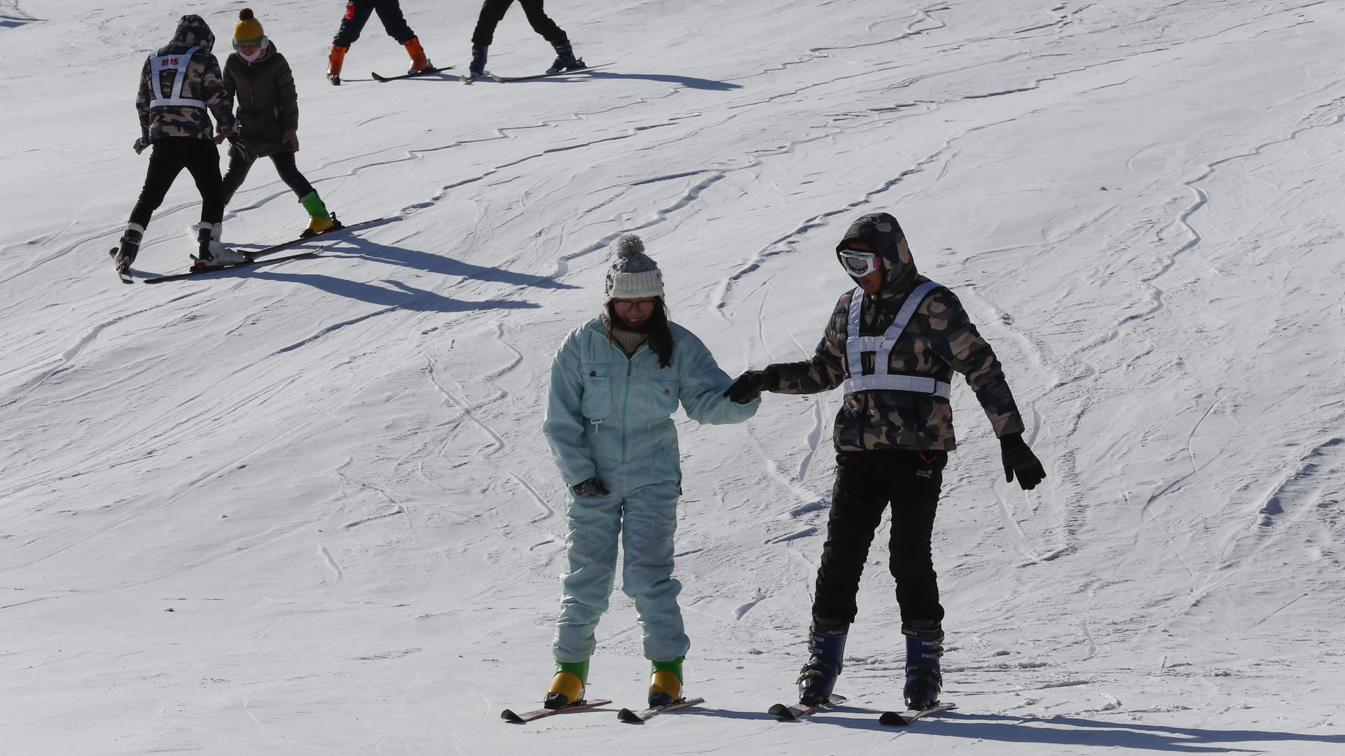 Auf einer Kunstschnee-Piste in Peling erhalten Skifahrer Unterricht | picture alliance / Rolex Dela Pe