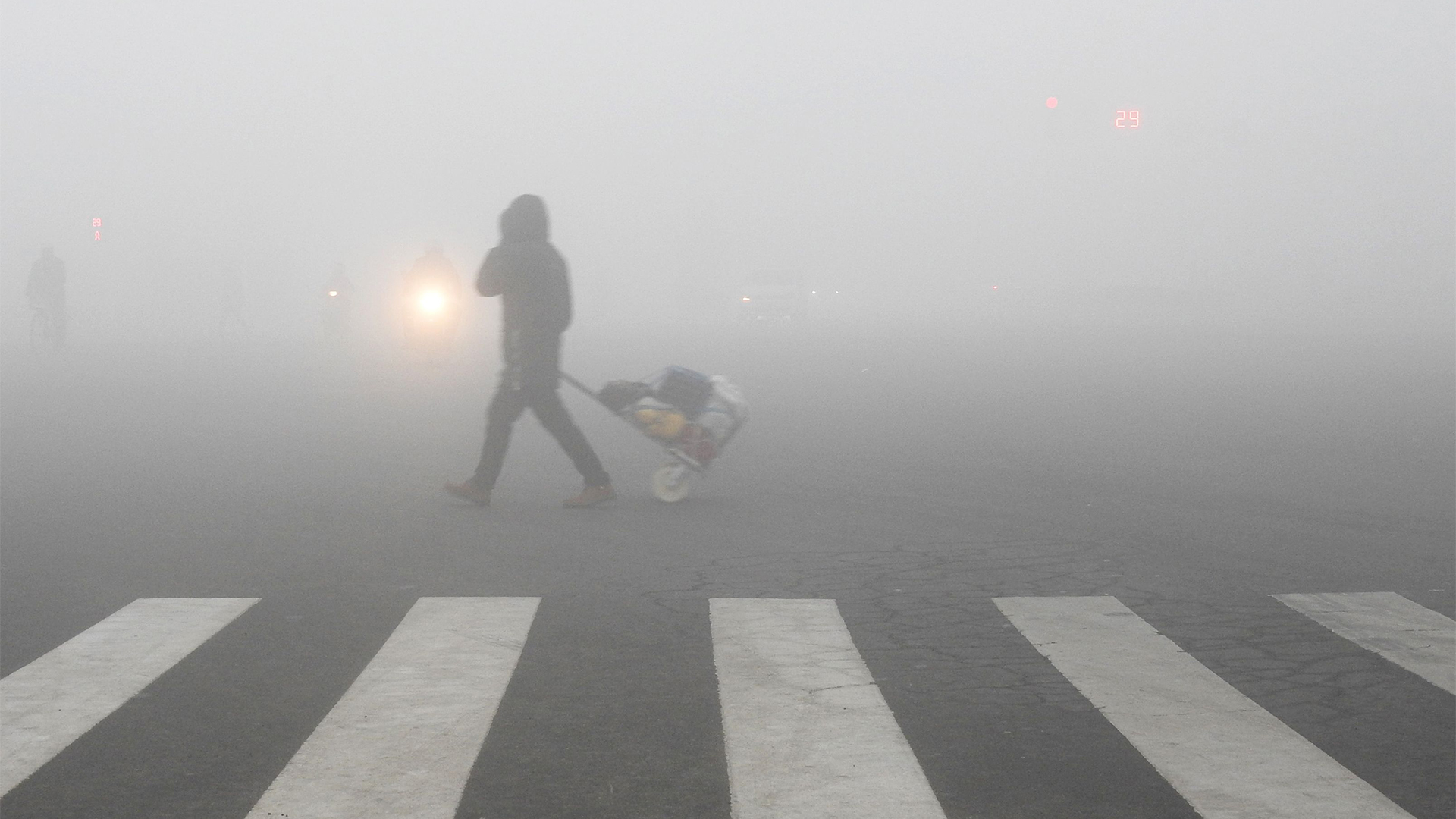 Ein Mann geht in Lianyungang über eine Straße, die von Smog eingehüllt ist | AFP