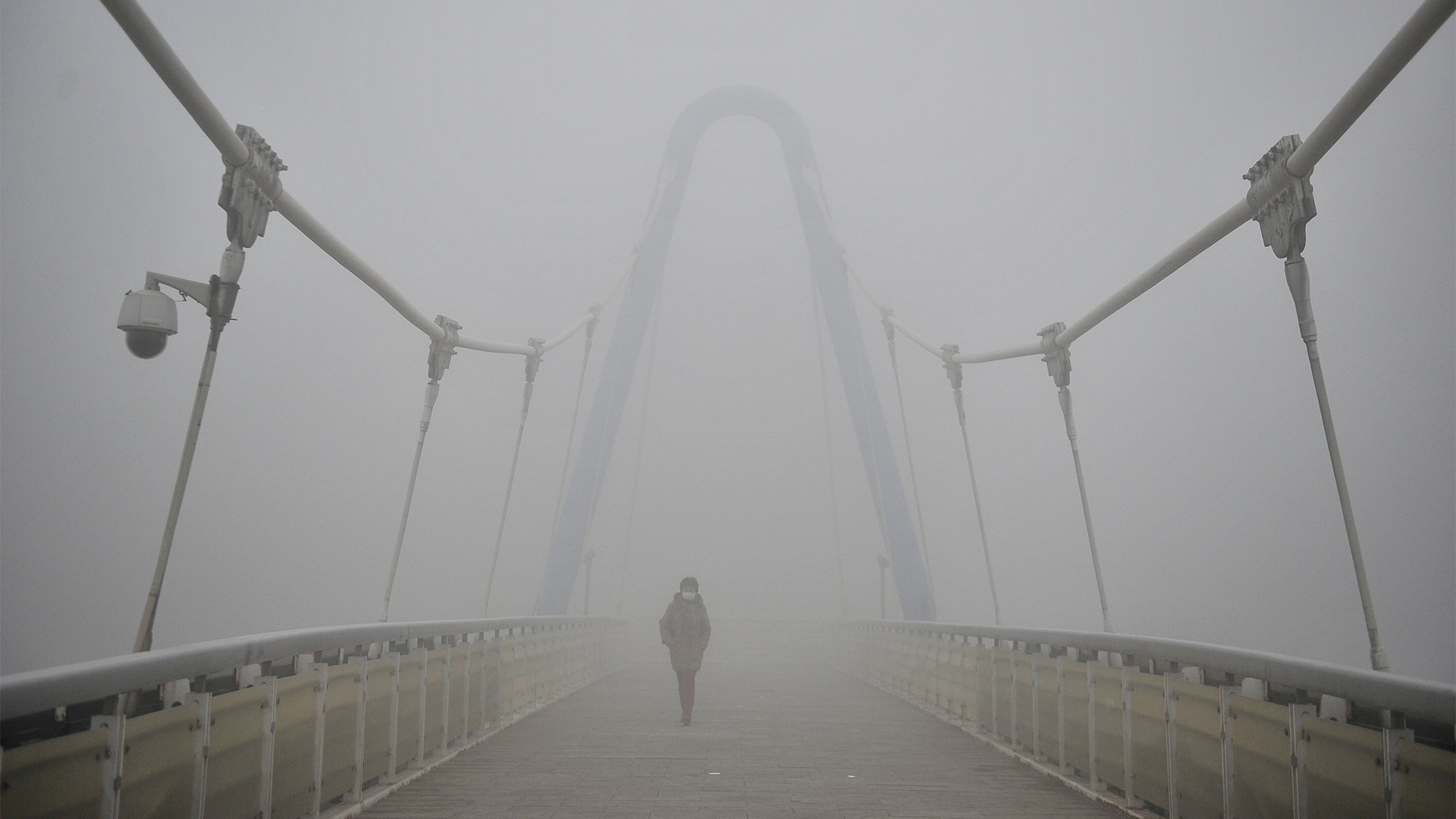 Eine Frau geht über eine von Smog eingehüllte Brücke in Tianjin | REUTERS