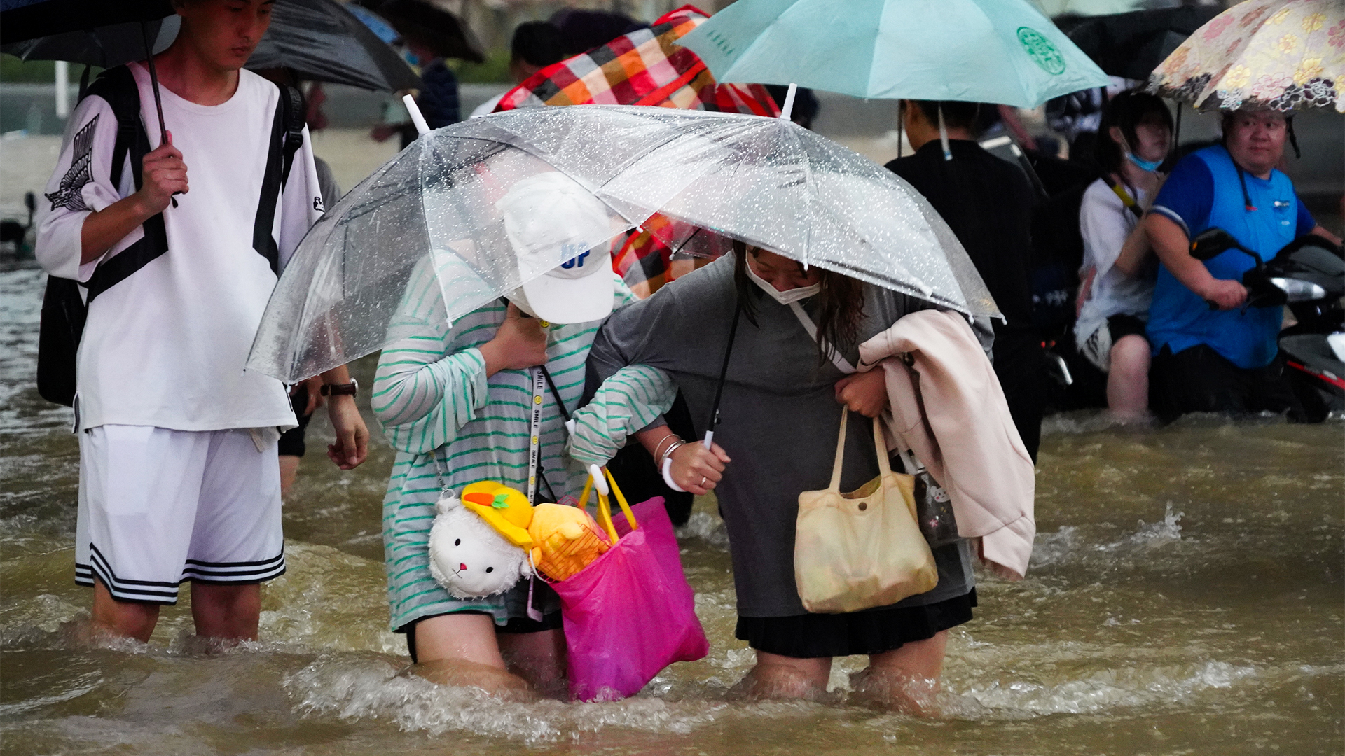 Anwohner der zentralchinesischen Provinz Henan auf einer überfluteten Straße | VIA REUTERS