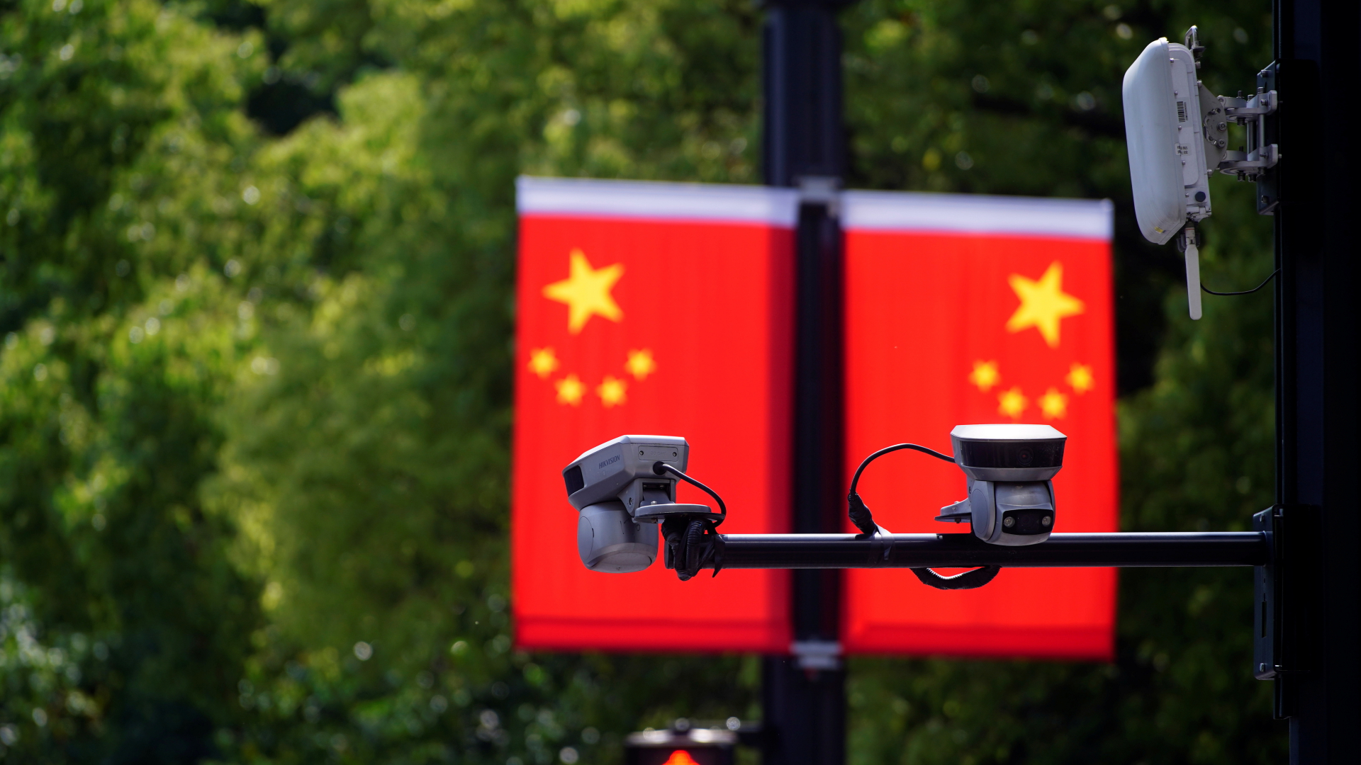 Überwachungskameras vor einer Flagge der Volksrepublik China in Shanghai.