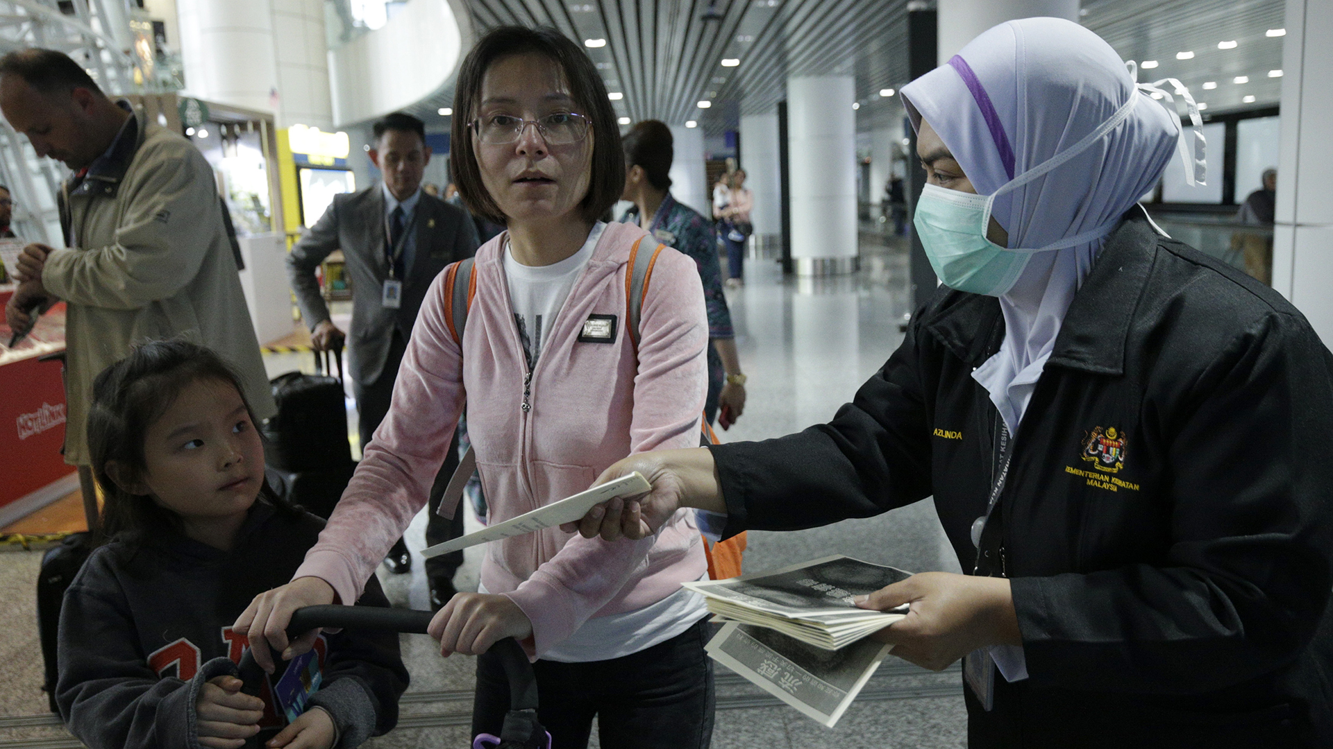 Am Flughafen von Kuala Lumpur in Malaysia werden Infobroschüren an Reisende aus China verteilt.