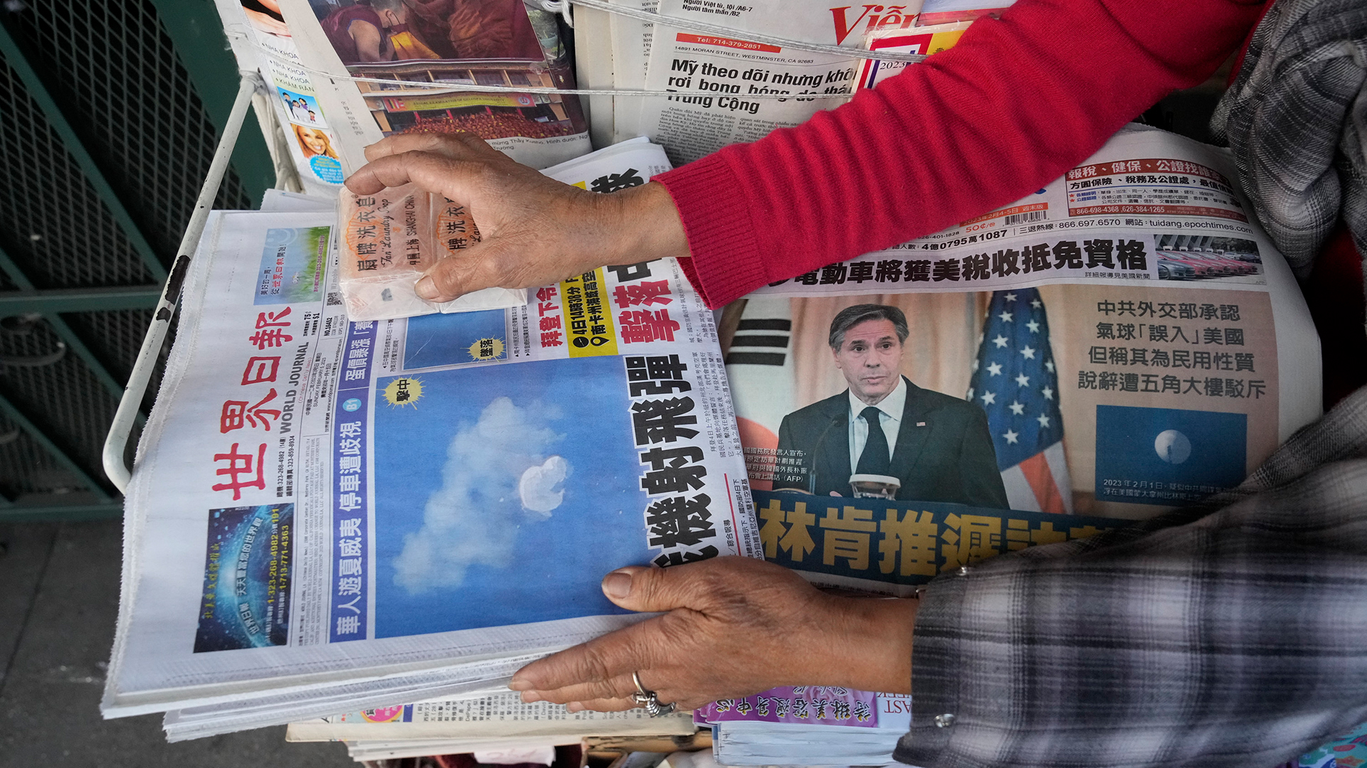 Chinesische Zeitungen liegen auf einem Stapel. | AP