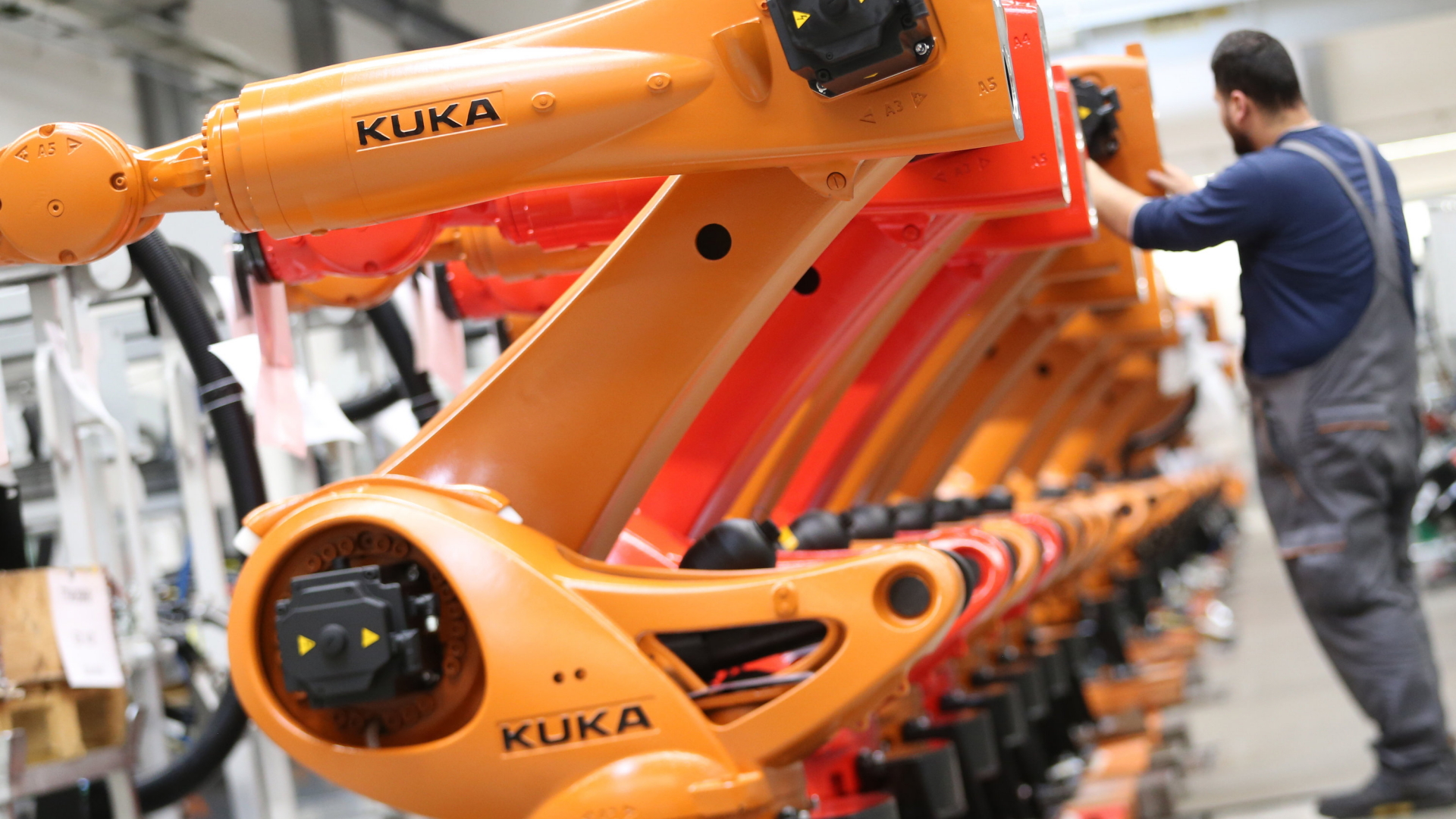 Kuka-Roboter werden in einer Produktionshalle der Kuka-Zentrale montiert. | Bildquelle: dpa