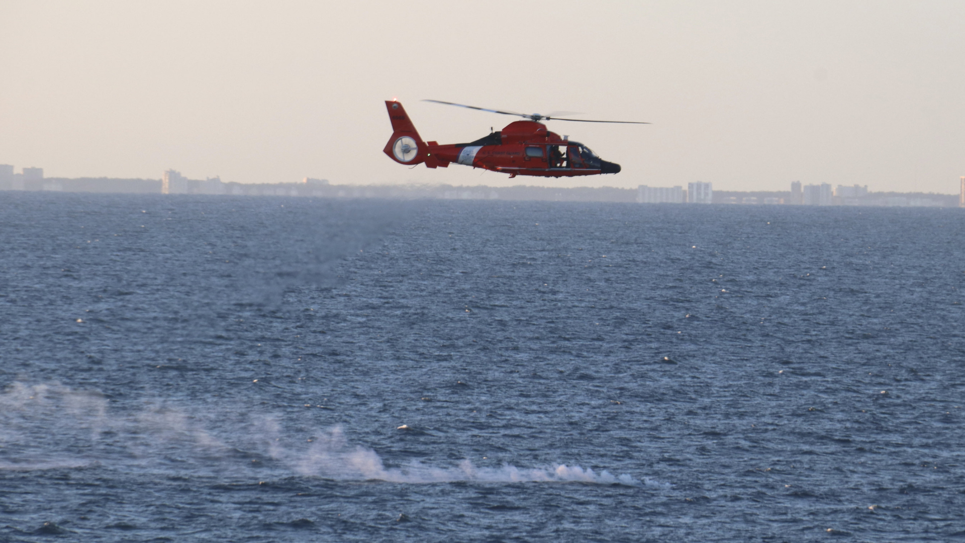 Ein Helikopter der US Navy fliegt vor der Küste South Carolinas über Trümmerteile des abgeschossenen chinesischen Ballons.  | AP