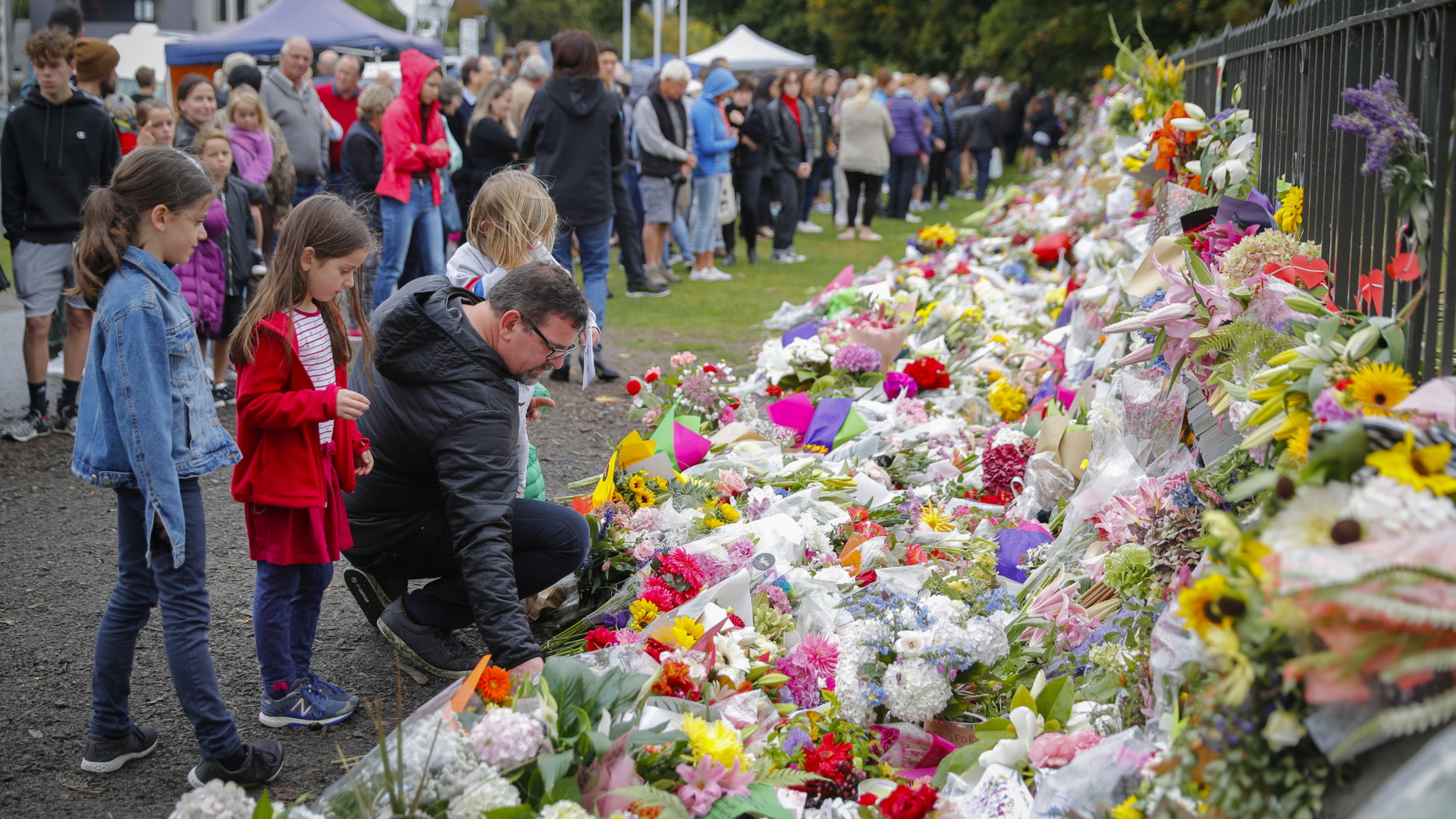Trauernde Menschen legen Blumen an einen Zaun in den Botanischen Gärten von Christchurch. | dpa