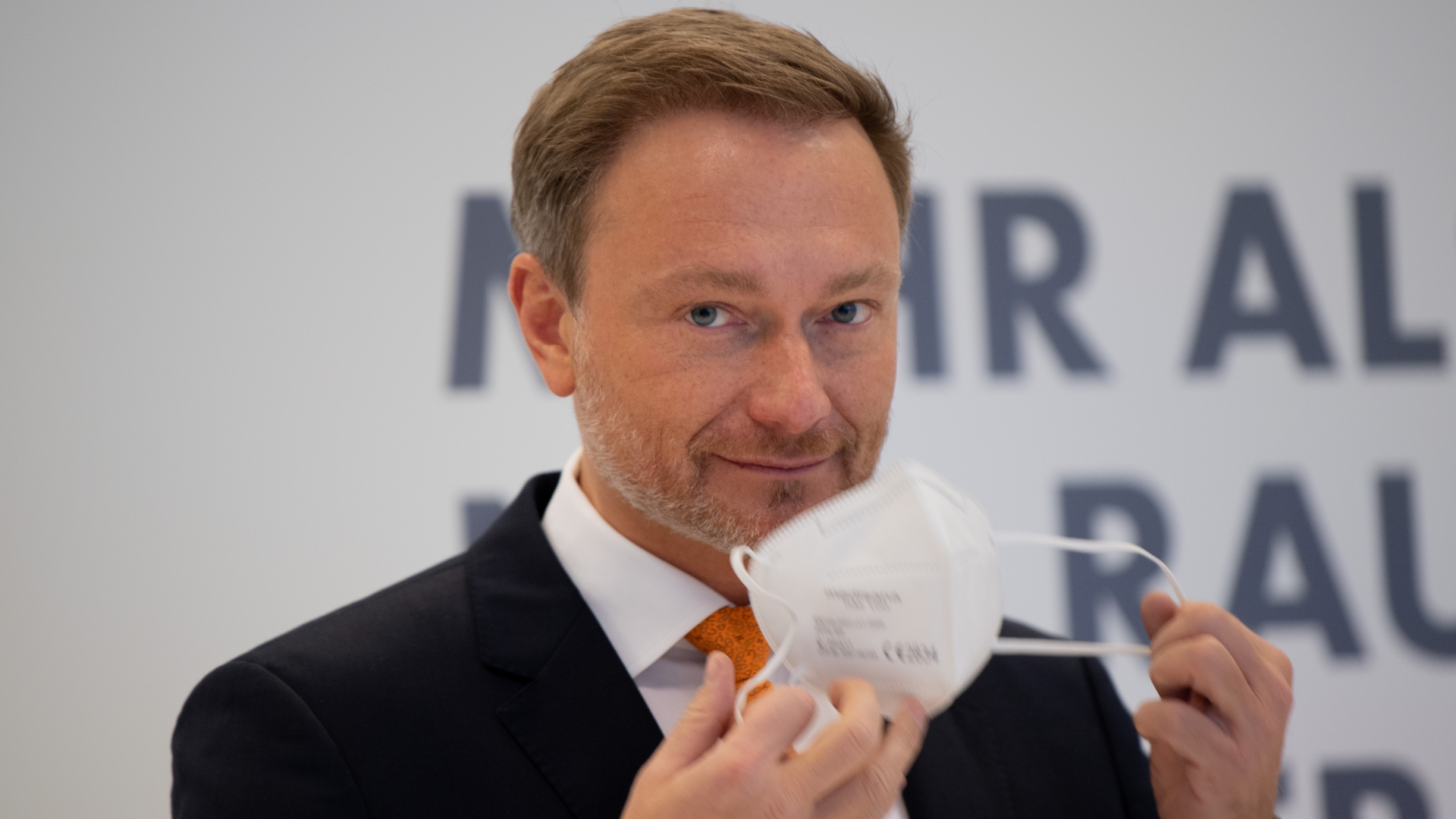 FDP-Parteichef Christian Lindner nimmt eine FFP2-Maske ab. | dpa