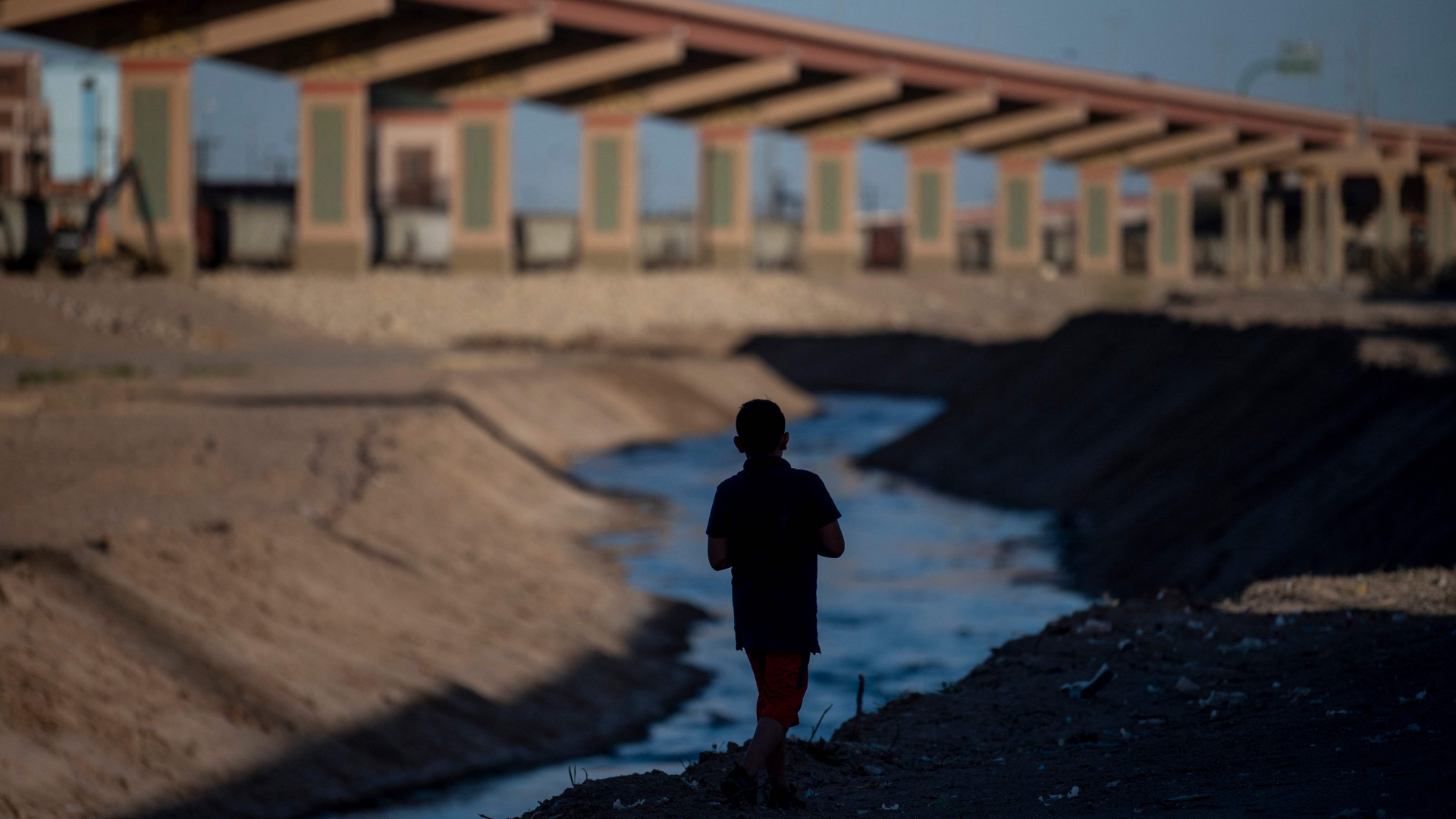 Ein Junge geht an einem Fluss in der mexikanischen Grenzstadt Ciudad Juarez entlang. | AFP