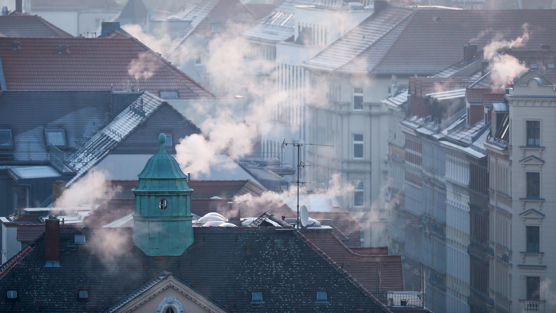  Sachsen, Leipzig: Rauch strömt aus den Kaminen auf den Dächern der Mehrfamilienhäuser.