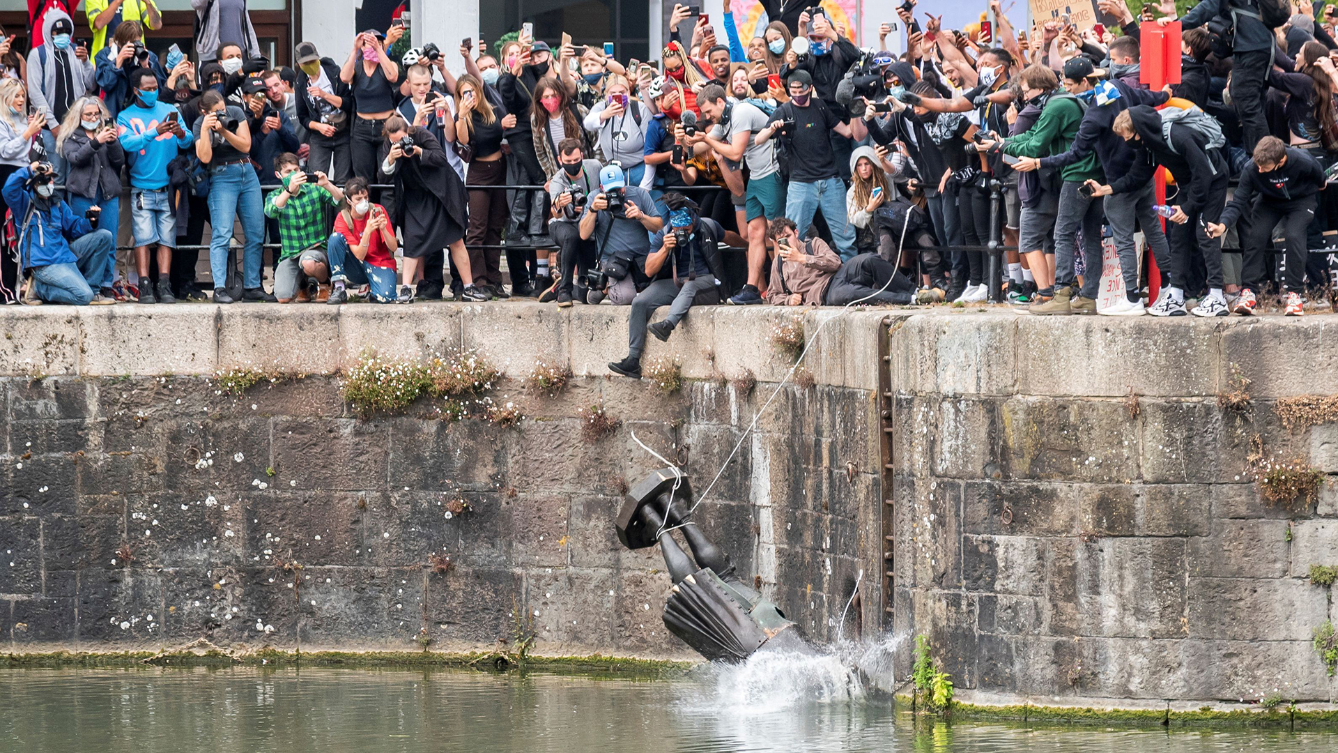Die Statue von Edward Colston fällt in Bristol ins Wasser und wird dabei von vielen Menschen gefilmt. | KEIR GRAVIL via REUTERS