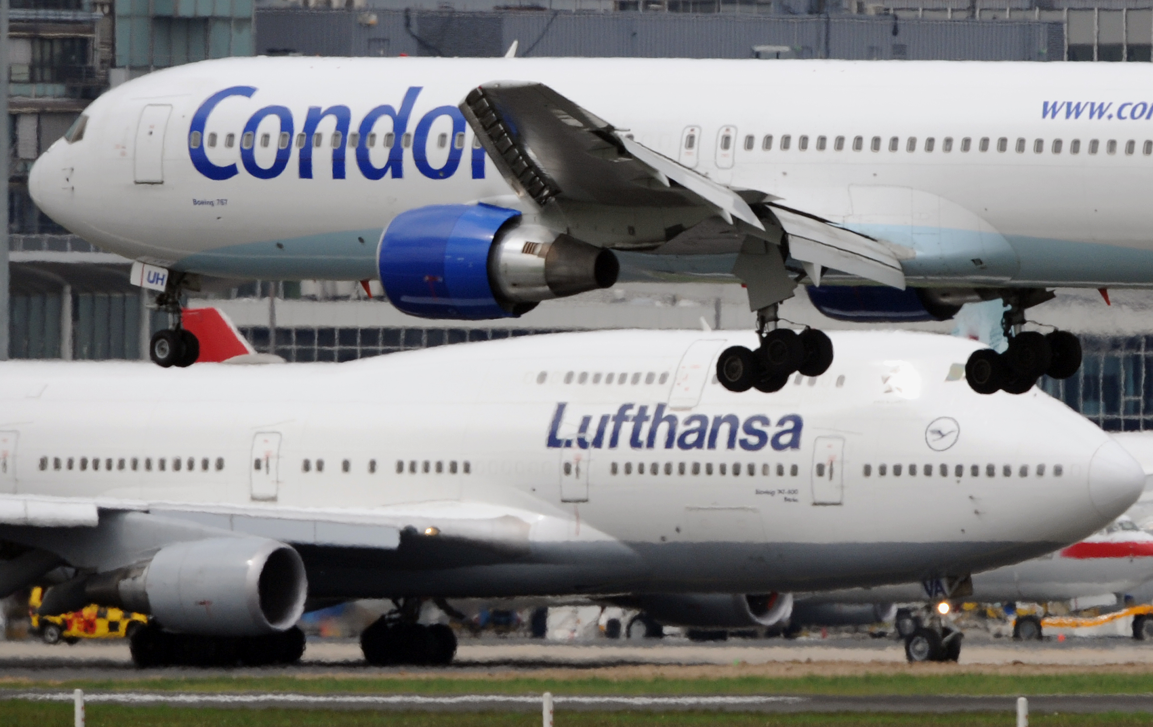 Lufthansa-Maschine parkt im Hintergrund bei der Landung einer Condor-Maschine | picture alliance/dpa