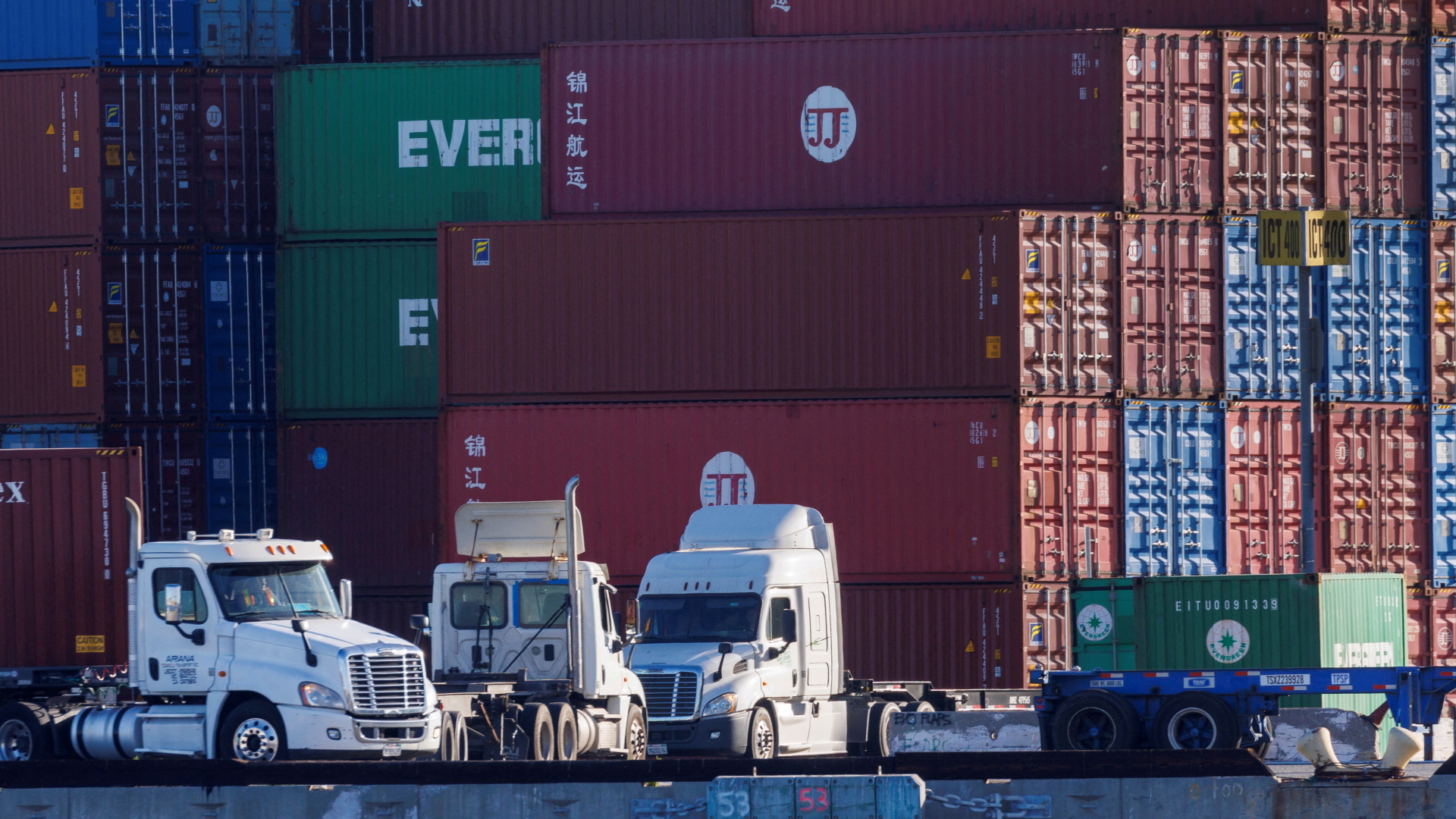 Lastwagen stehen vor gestapelten Containern im Hafen von Los Angeles | REUTERS