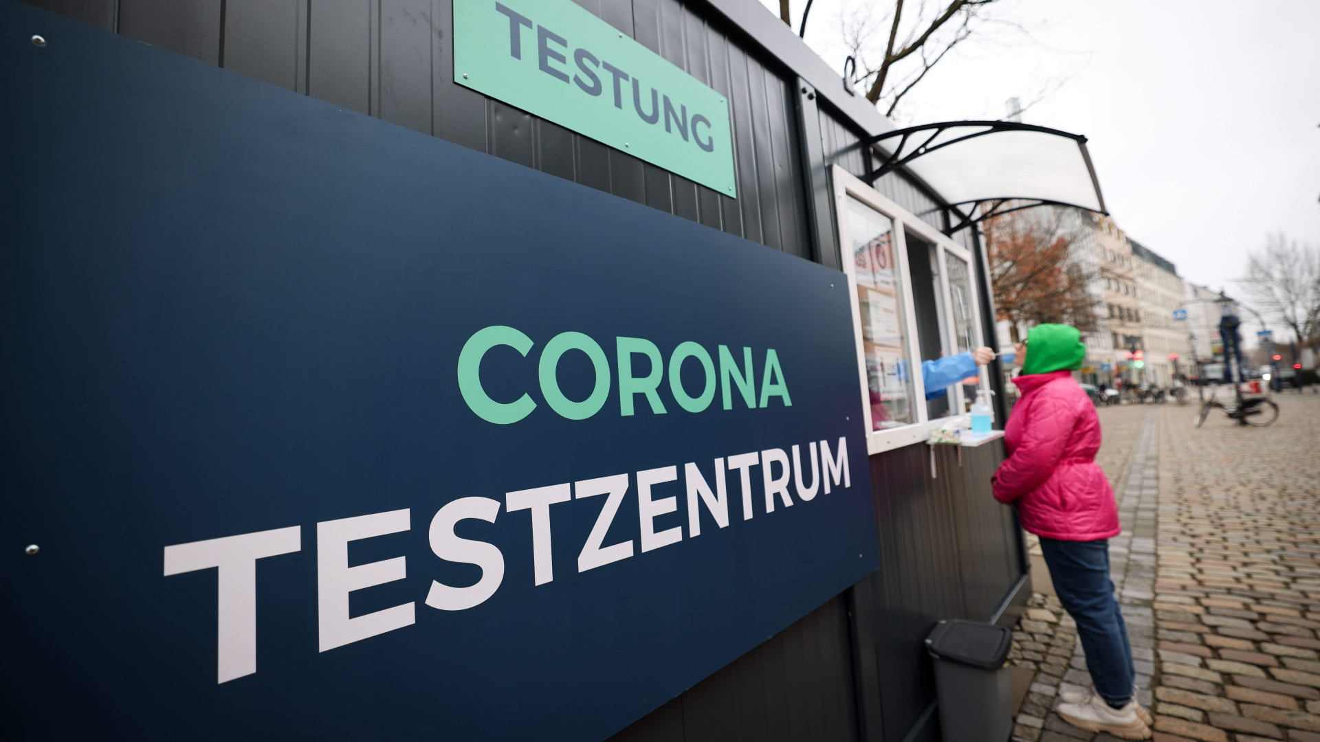 Eine Frau steht an einem Corona Testzentrum im Stadtteil Hamburg-Altona und bekommt einen Schnelltest. | dpa