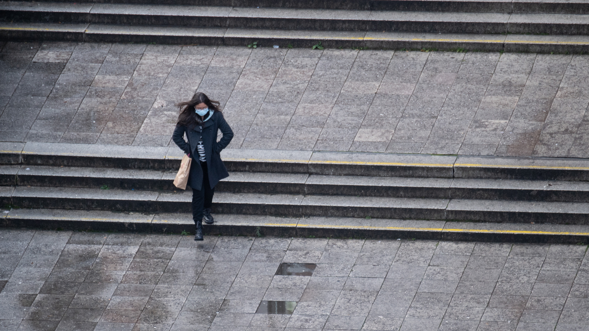 Eine Frau mit Maske geht allein über die Hauptwache in Frankfurt am Main. | dpa