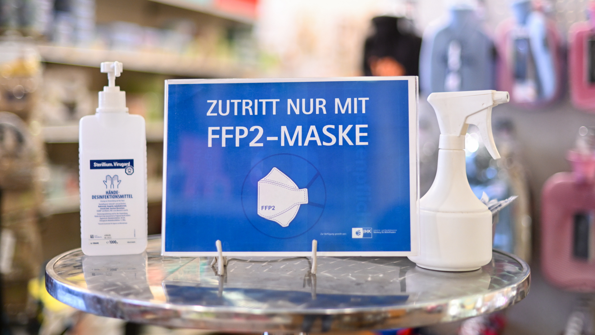 Ein Hinweisschild mit der Aufschrift "Zutritt nur mit FFP2-Maske" steht in einem Haushaltswarenladen in München. (Archivbild) | dpa