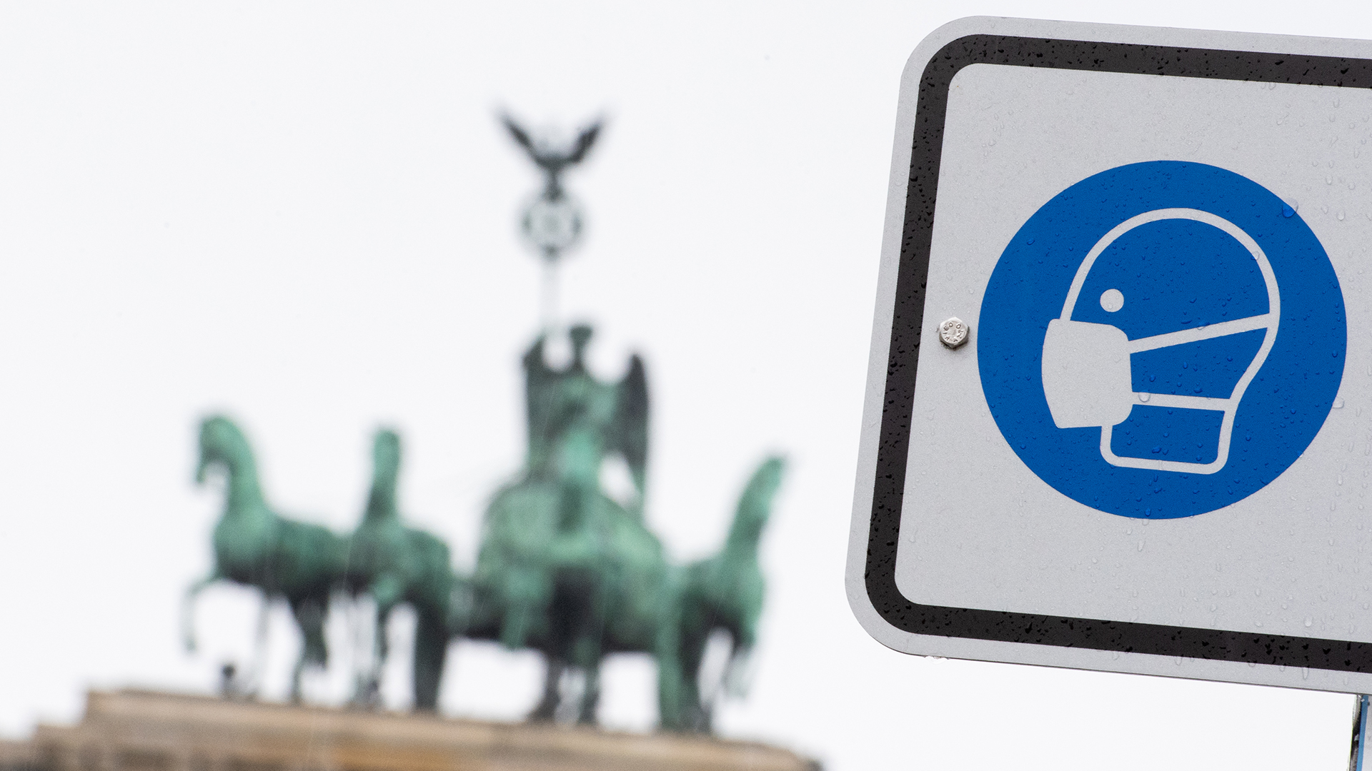 Am Pariser Platz vor dem Brandenburger Tor weist ein Hinweisschild auf die Maskenpflicht hin. (Archivbild) | dpa