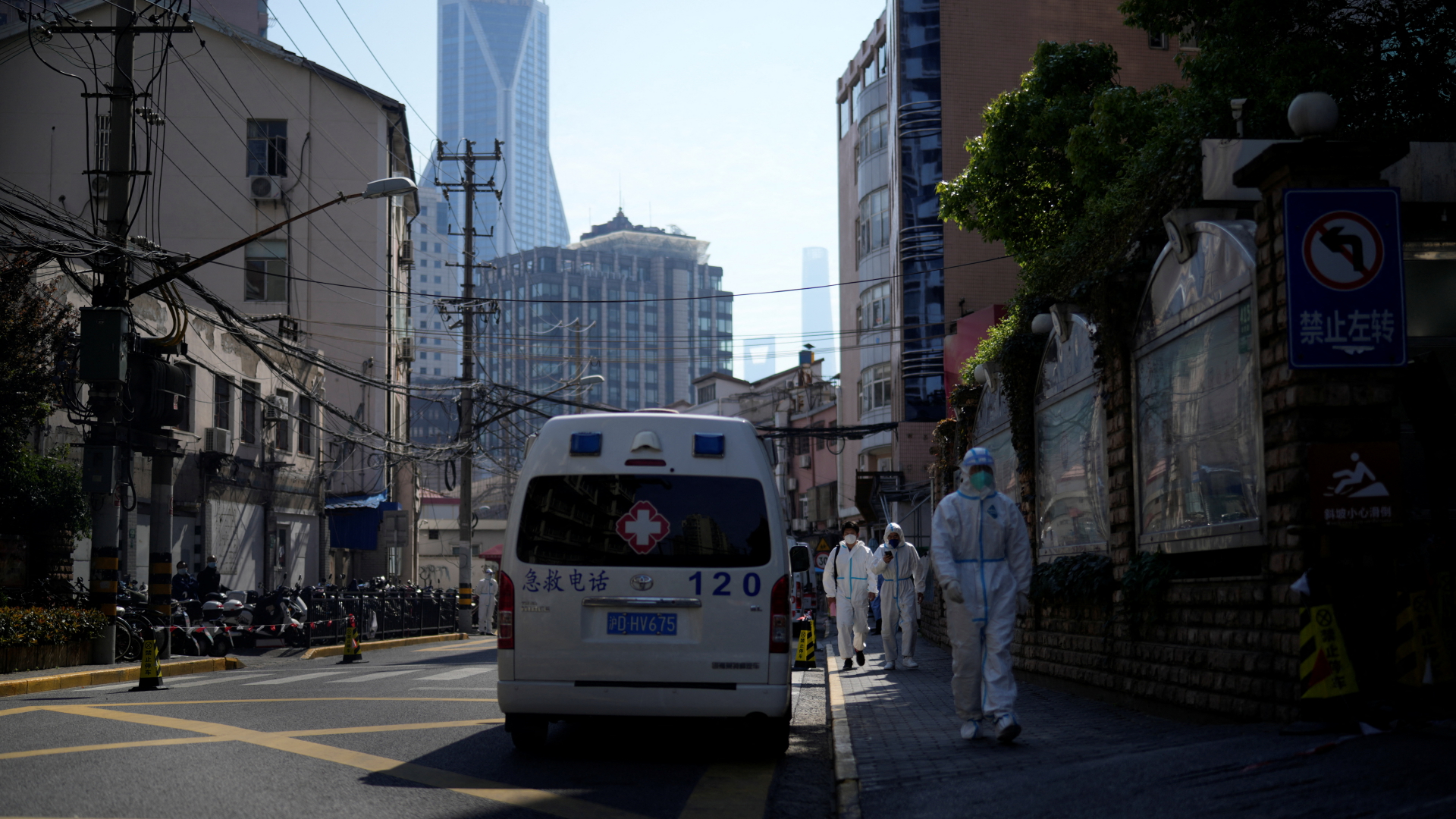 Arbeiter in Schutzanzügen gehen während des Corona-Lockdowns in Shanghai eine Straße entlang | REUTERS