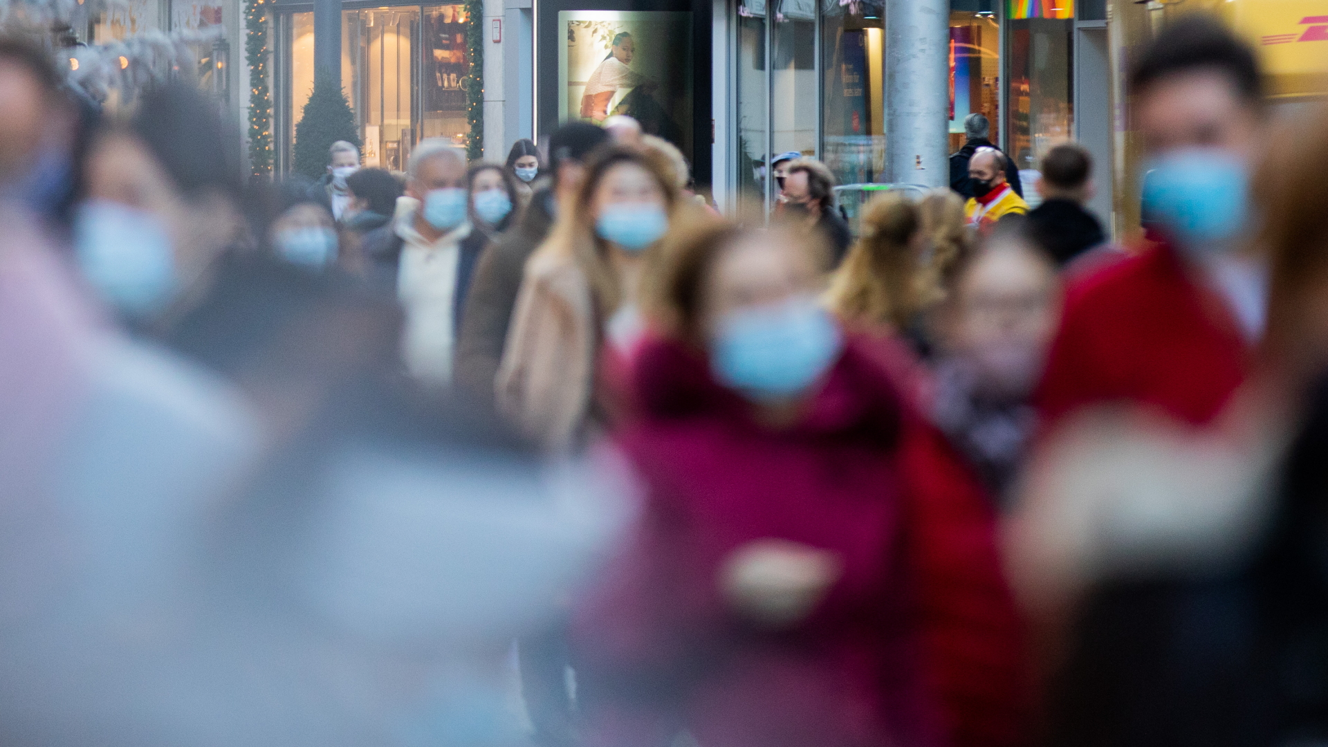 Nordrhein-Westfalen, Düsseldorf: Menschen mit Mund-Nasen-Schutz gehen durch eine Fußgängerzone. | dpa