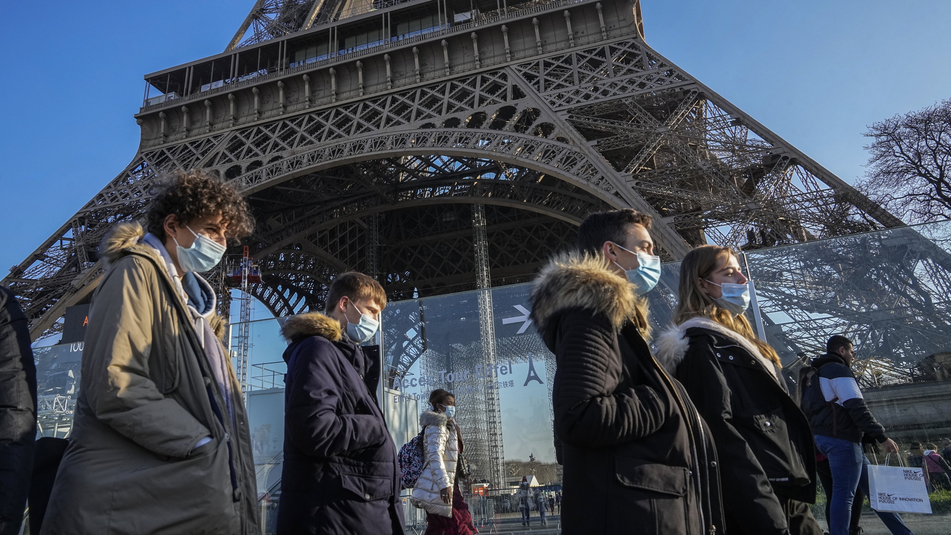Menschen mit Masken vor dem Eiffelturm in Paris | dpa