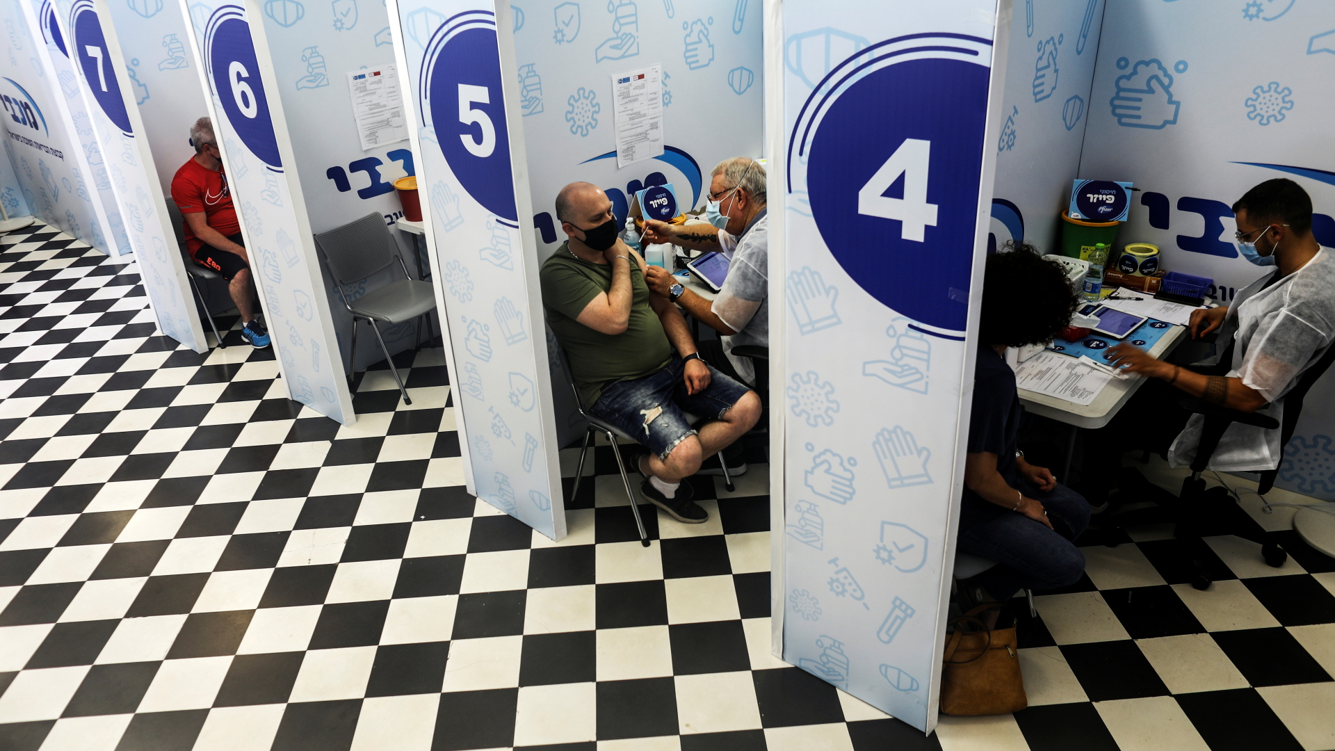 Mehrere Menschen in Kabinen eines Impfzentrums im israelischen Rishon Lezion erhalten eine Auffrischungsimpfung gegen das Coronavirus. Archivbild | REUTERS