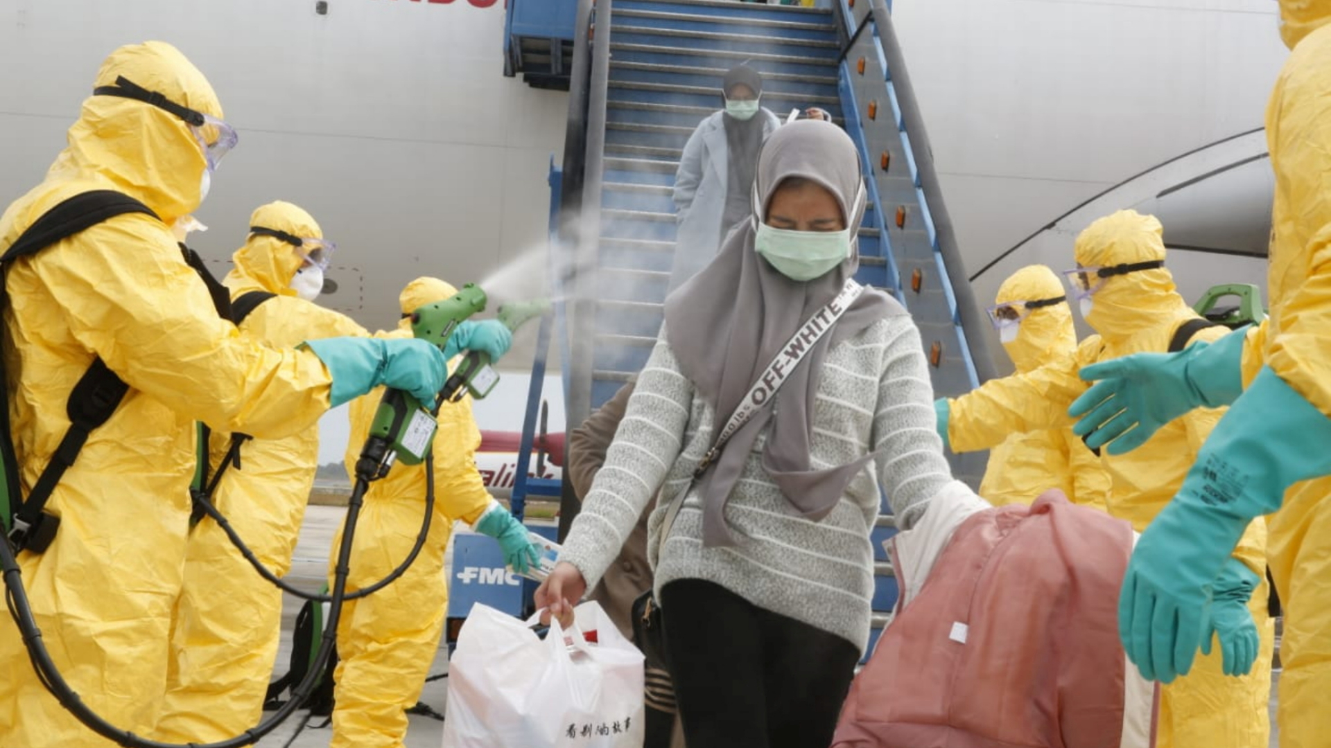 Passagiere, die aus aus Wuhan ankommen, lassen sich am Flughafen Hang Nadim in Indonesien absprühen. | REUTERS