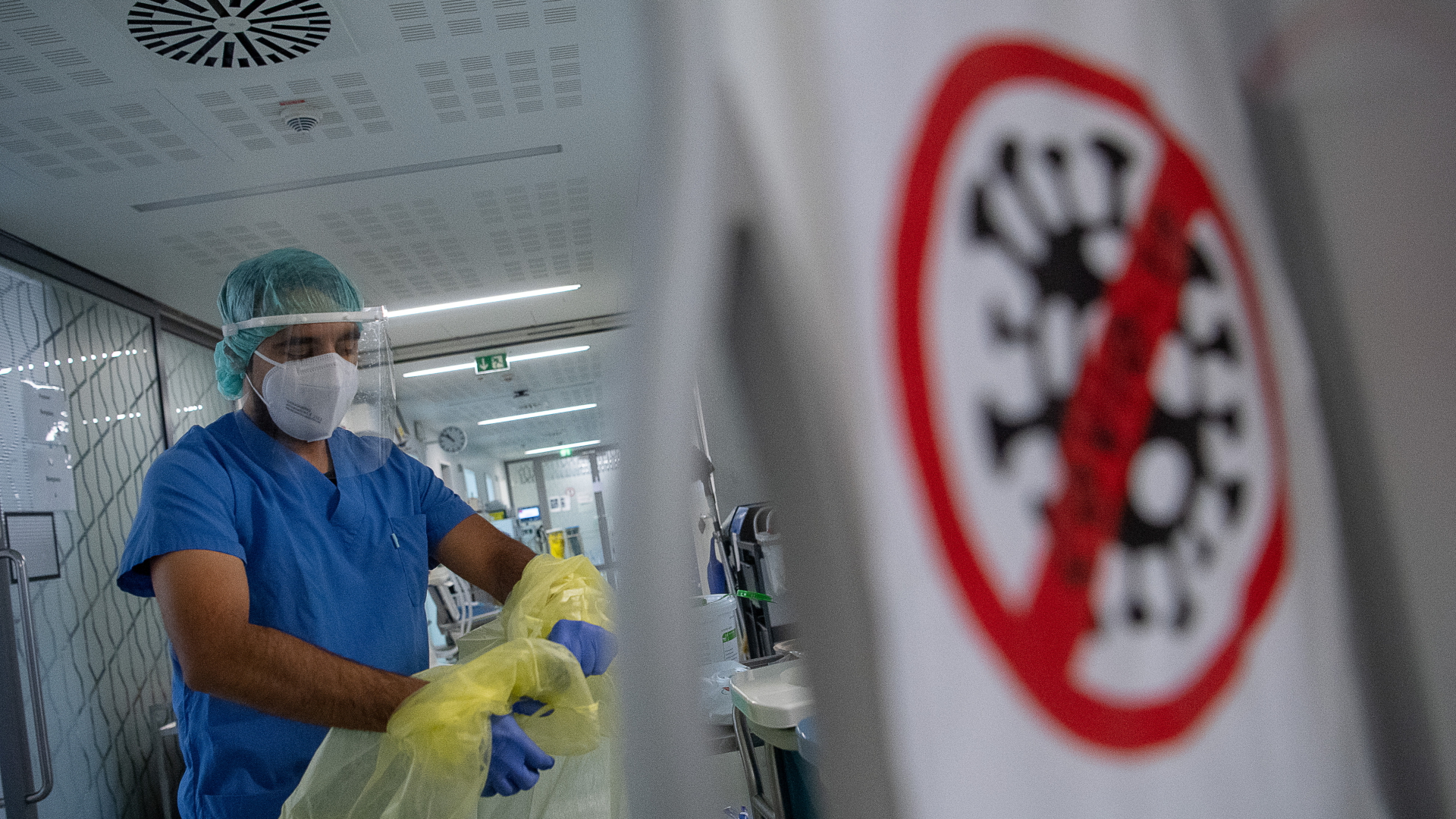 Ein Pfleger zieht beim Verlassen der Intensivstation für Corona-Patienten am Sana Klinikum Offenbach seinen Schutzkittel aus.  | dpa