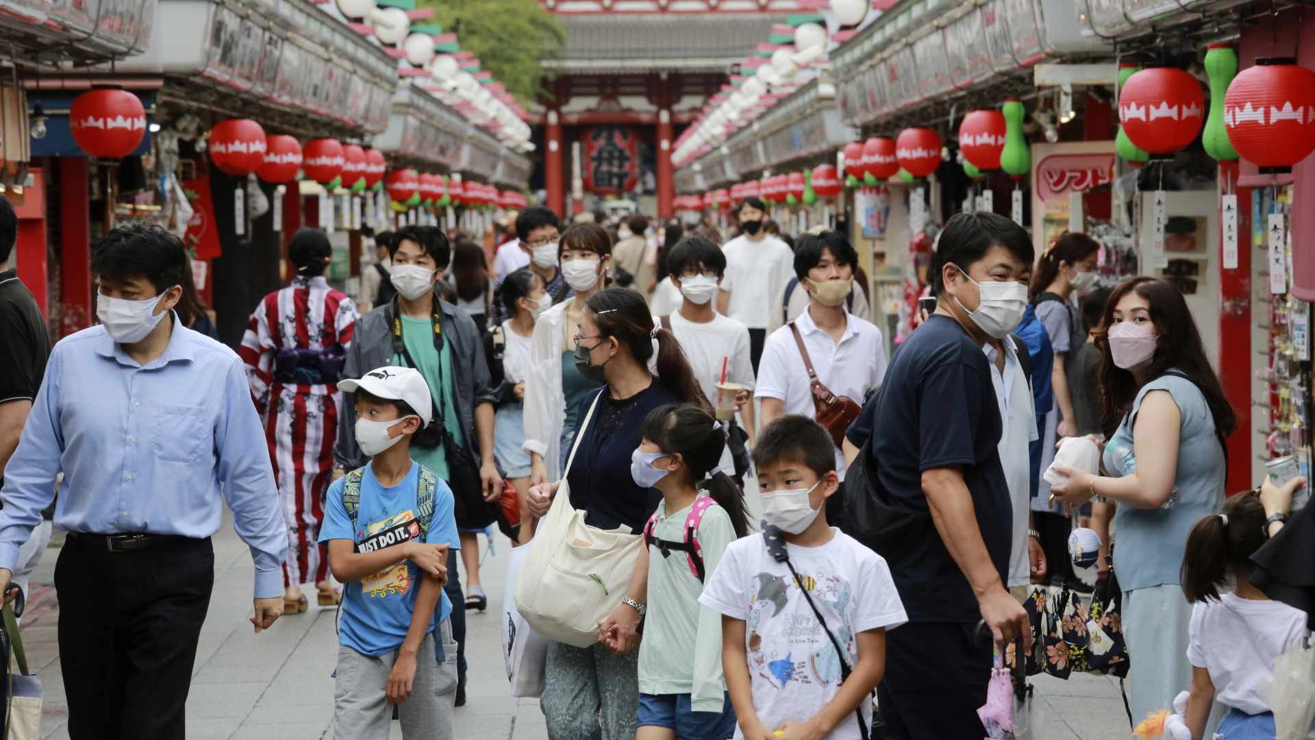 Passanten gehen mit Mund-Nasen-Schutz durch die Einkaufsstraße Asakusa Nakamise in Tokio. | dpa