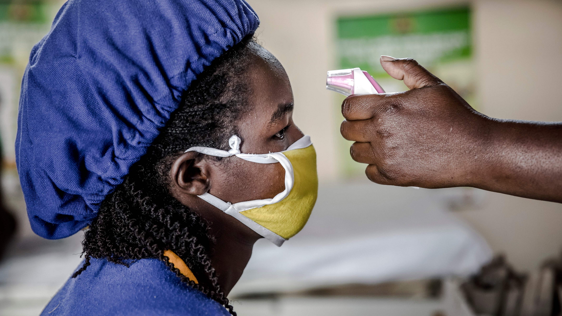 Bei einer kenianischen Arbeiterin wird vor Dienstbeginn Fieber gemessen | AFP