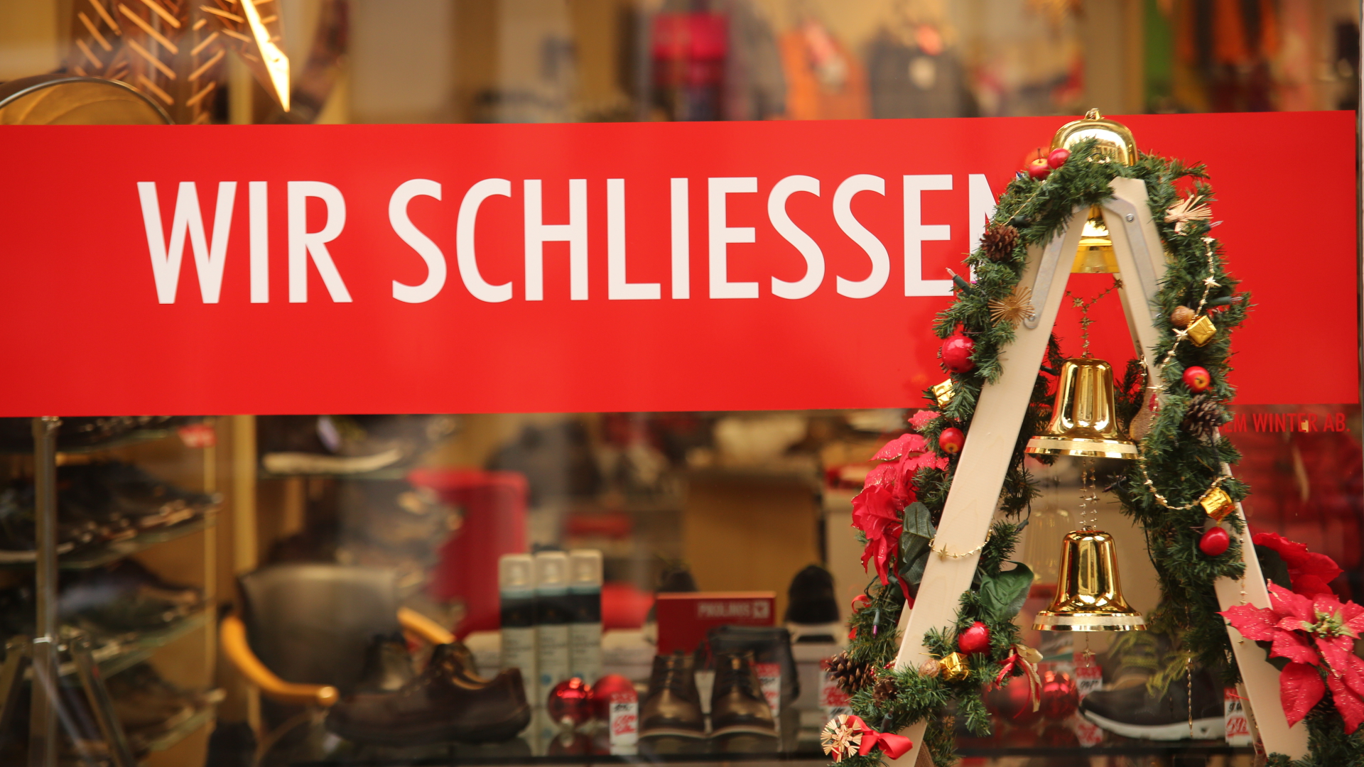 An einem Schaufenster mit Weihnachtsdekoration steht der Schriftzug "Wir schließen".| Bildquelle: dpa