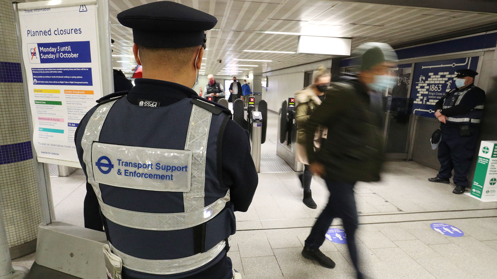 Ein Sicherheitsbeamter überprüft die Einhaltung der Corona-Maßnahmen an der U-Bahn-Station King's Cross in London. | dpa