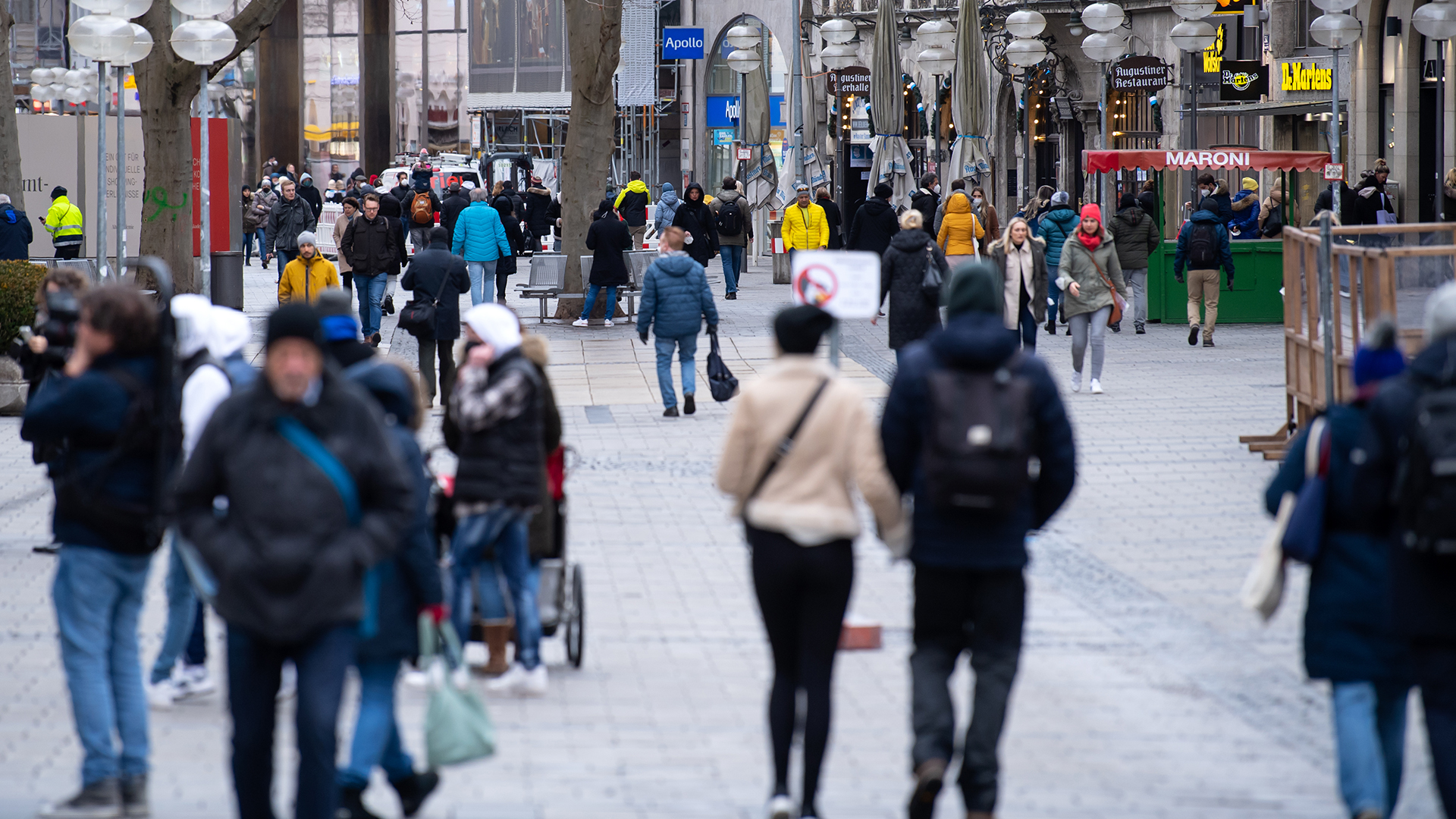 Passanten laufen durch die Fußgängerzone in München. | dpa