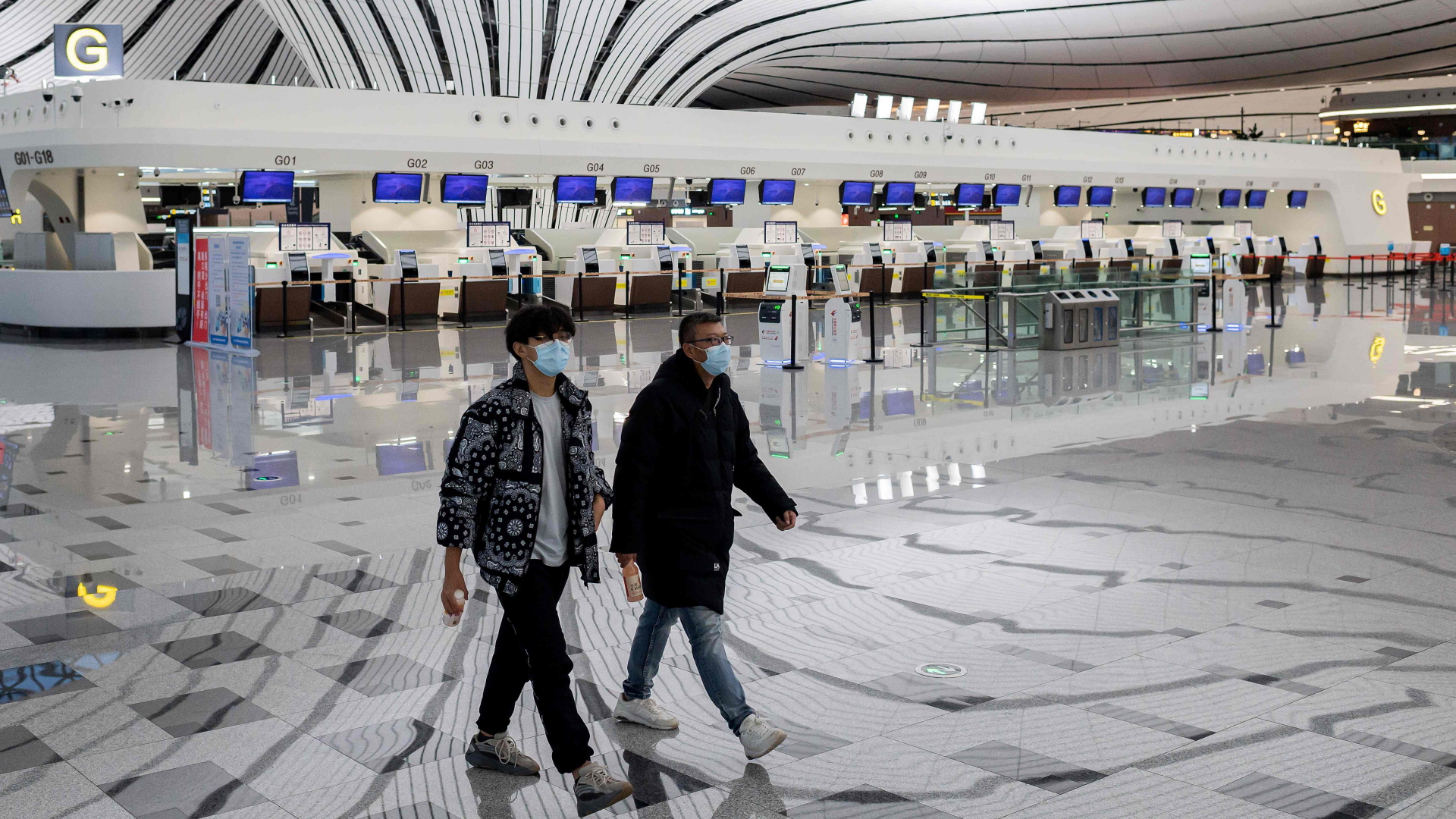 Menschen mit Mundschutz am Flughafen in Peking