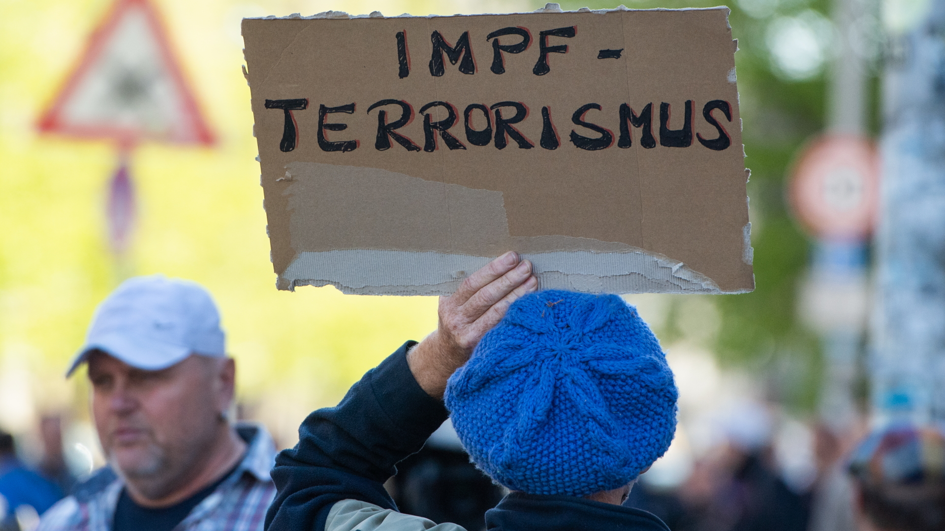 Ein Demonstrant hält ein Schild mit dem Wort "Impfterrorismus" bei einer Protestaktion in Berlin | dpa