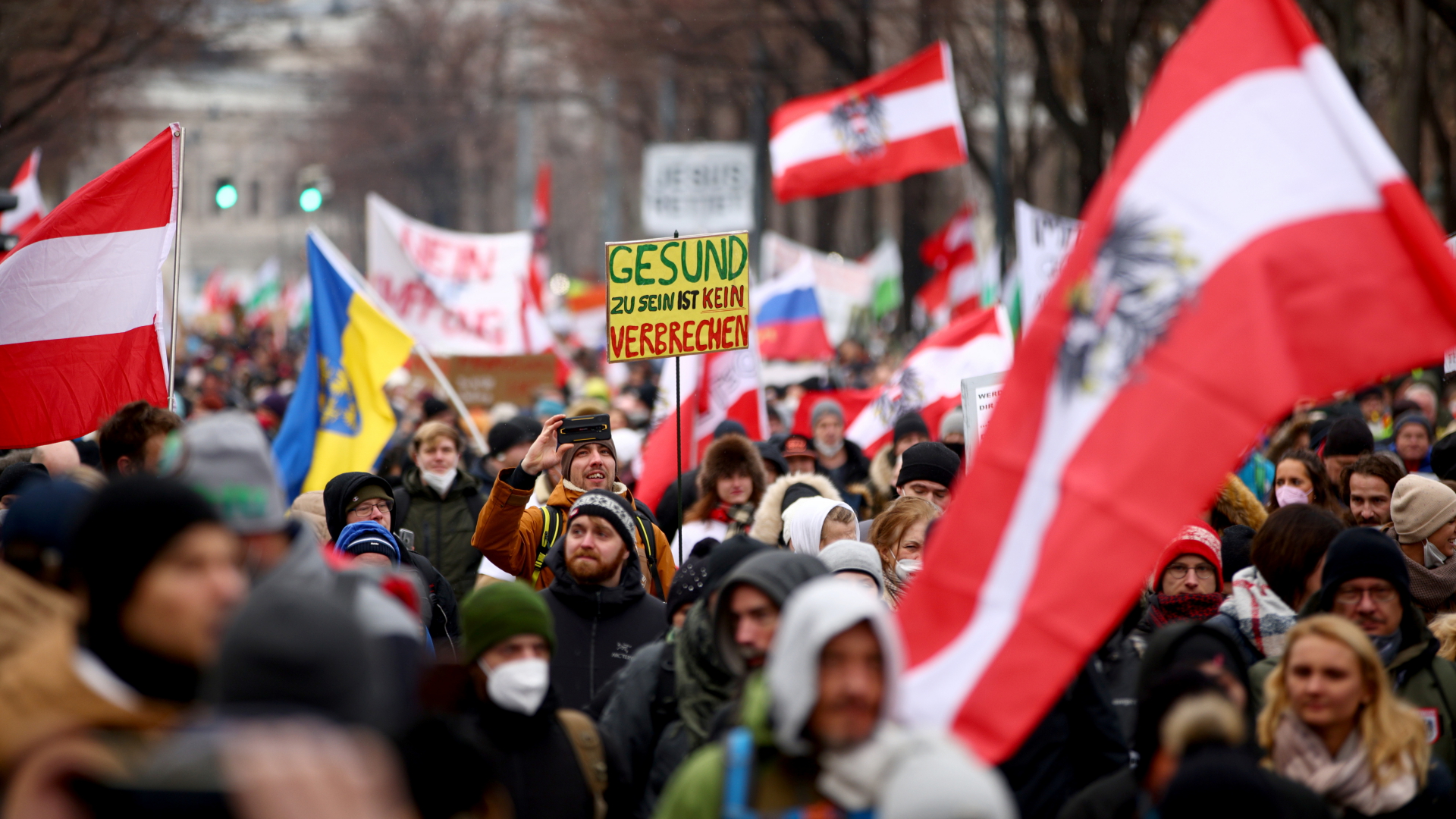 Menschen mit Fahnen und Transparenten protestieren in Wien gegen die Corona-Maßnahmen in Österreich. | REUTERS