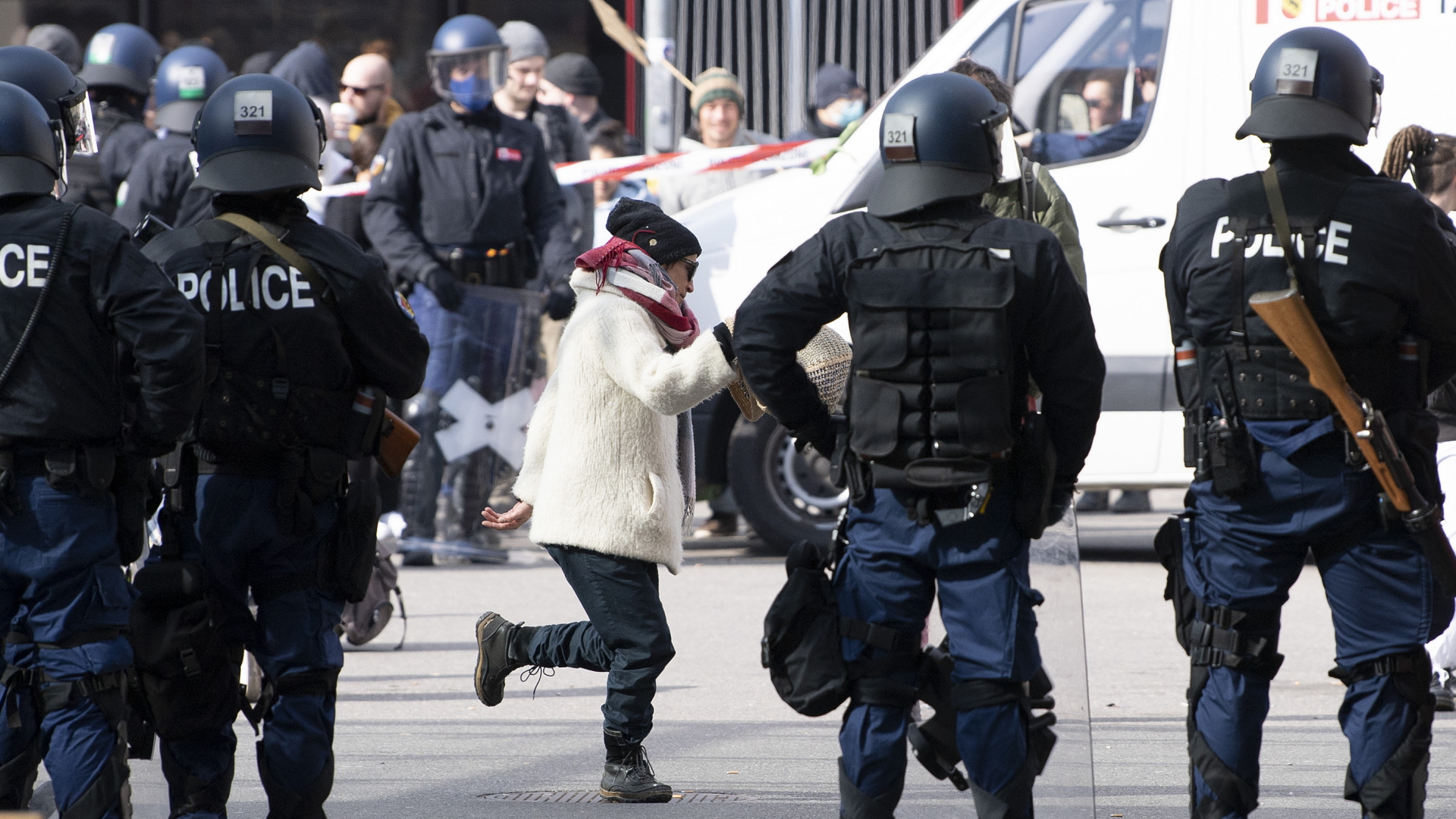 Schweiz: In Bern tanzt eine Frau zwischen Polizisten bei einer Demonstration gegen die verordneten coronabedingten Maßnahmen. | dpa