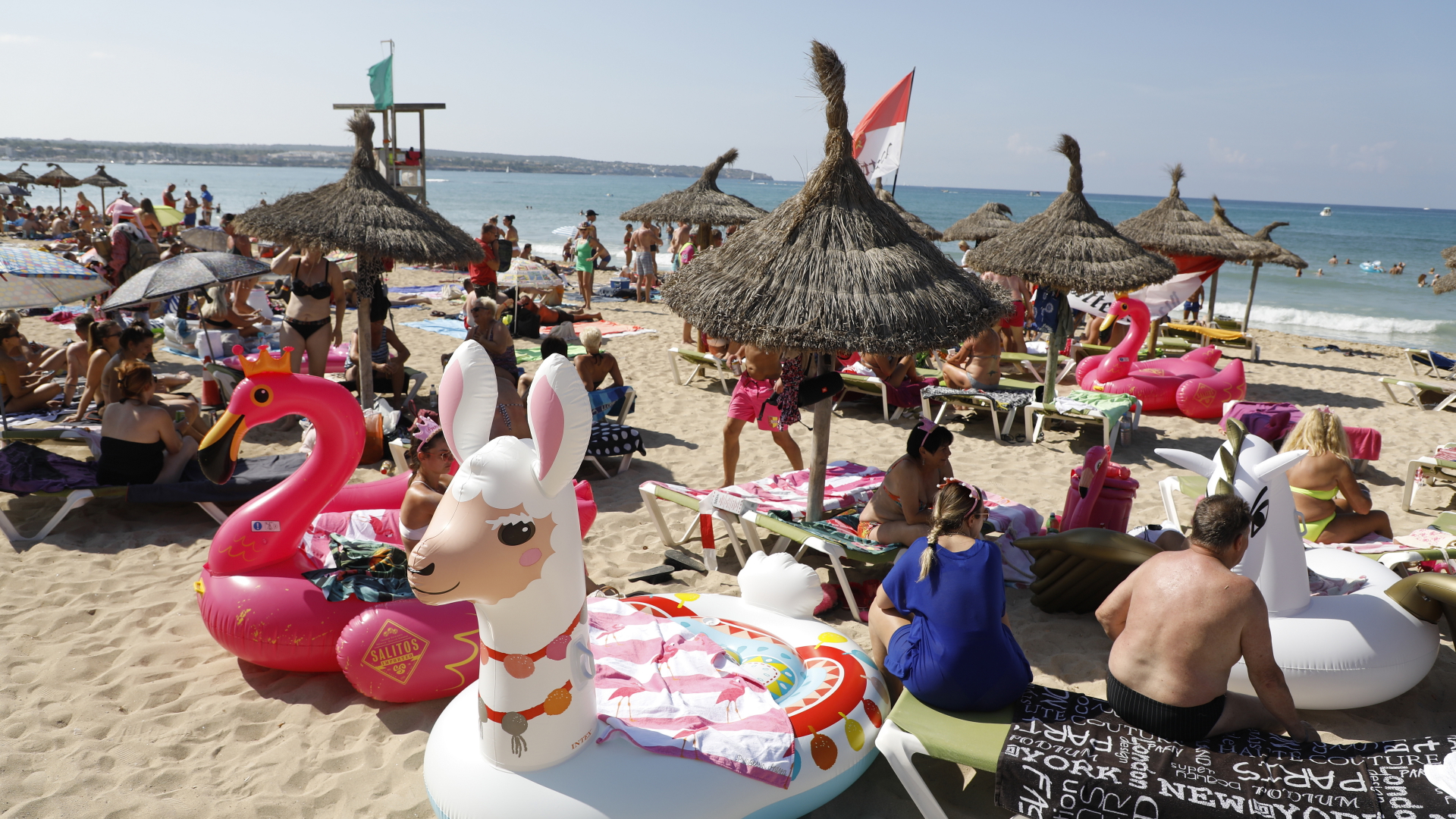 Badegäste unter Sonnenschirmen an einem Strand auf der Insel Mallorca | dpa