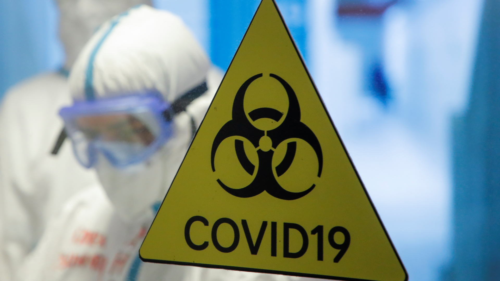 Ein gelbes Gefahrendreieck mit der Aufschrift "Covid-19" klebt an einer Glastür in einem temporären Corona-Krankenhaus in Moskau.
