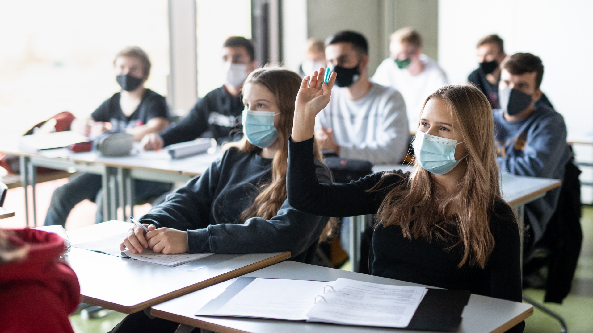 Schülerinnen und Schüler in München nehmen mit Mund- und Nasenschutz am Unterricht teil. (Archivbild)