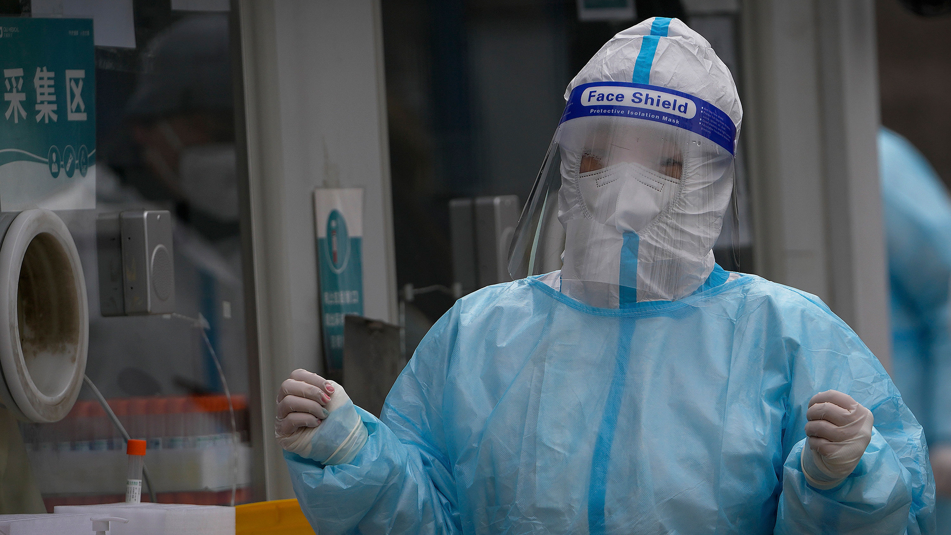 Eine medizinische Mitarbeiteri in einem Schutzanzug bereitet sich auf die Untersuchung von Personen in einer mobilen Coronavirus-Testanlage in Peking vor. | AP