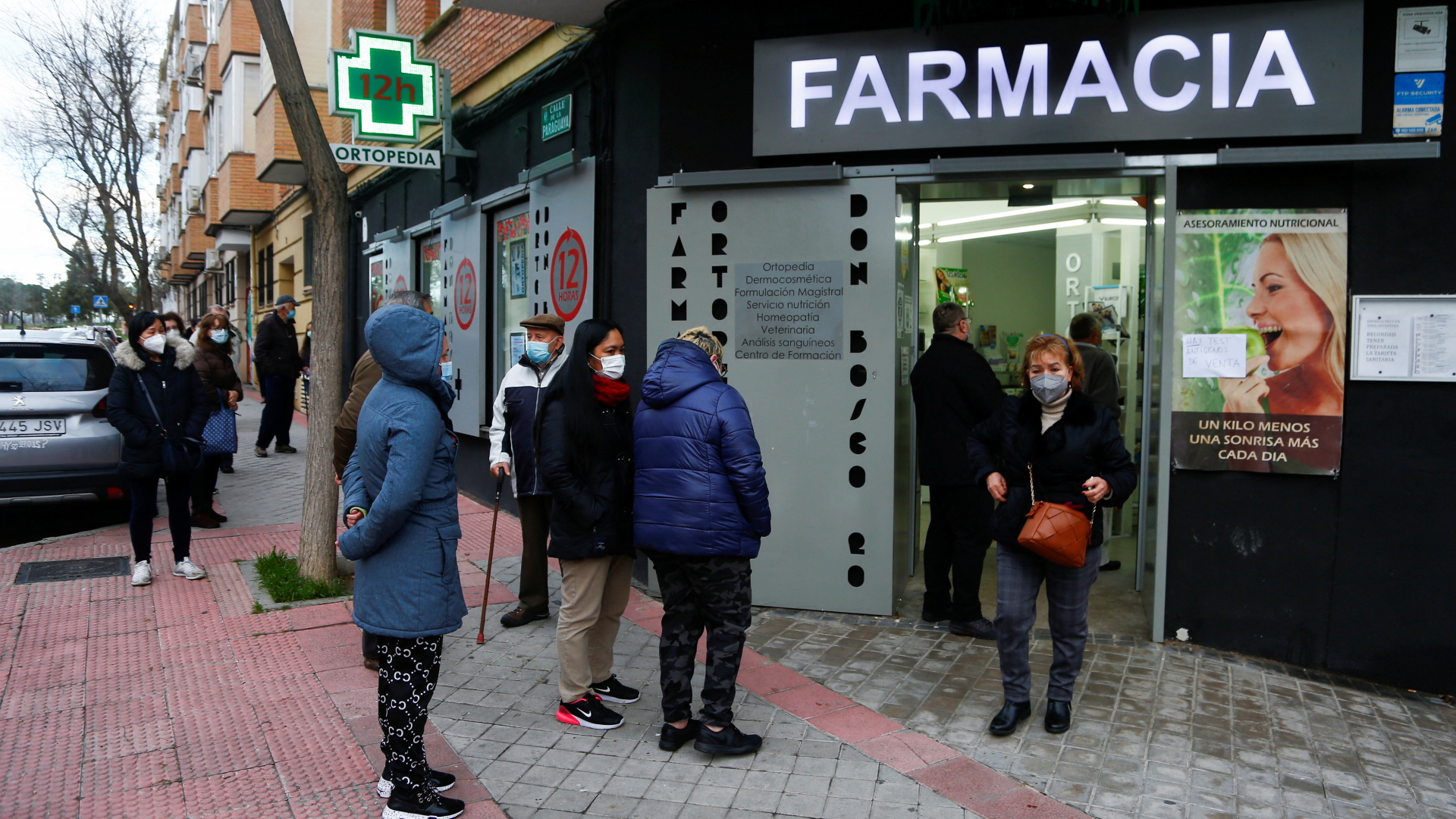 Menschen stehen in einer Schlange vor einer Apotheke in Madrid, die Corona-Tests anbietet. | REUTERS
