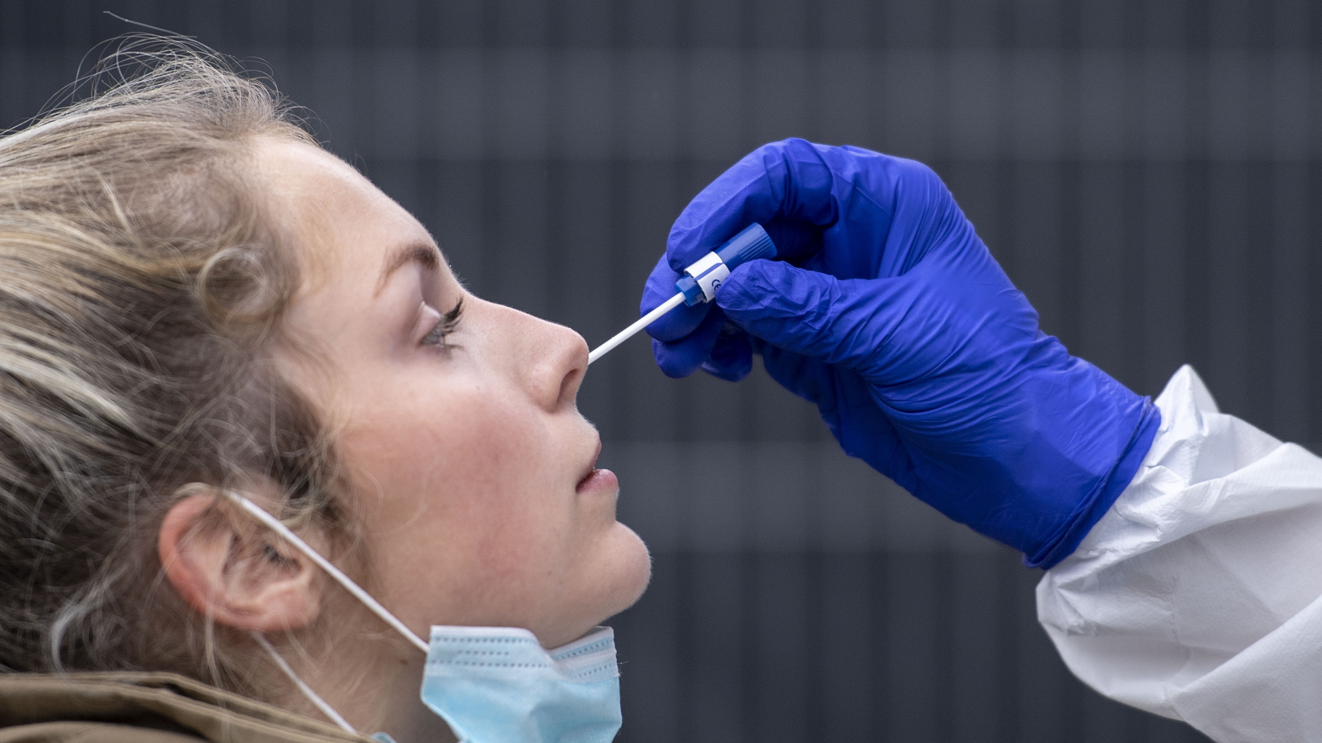 Eine Frau bekommt einen Nasenabstrich an einer Corona-Teststation | dpa