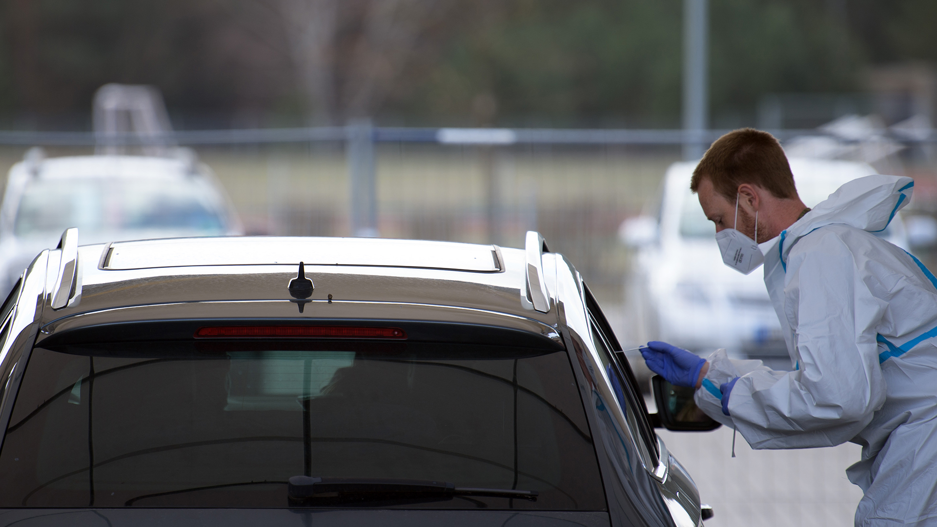 Ein Mitarbeiter testet in Oranienburg/Ot Lehnitz (Brandenburg) in einem Zelt auf einem Parkplatz des "Drive in"-Corona-Test die Insassen eines Autos mittels Nase-Rachen-Abstrich auf Corona.  | dpa