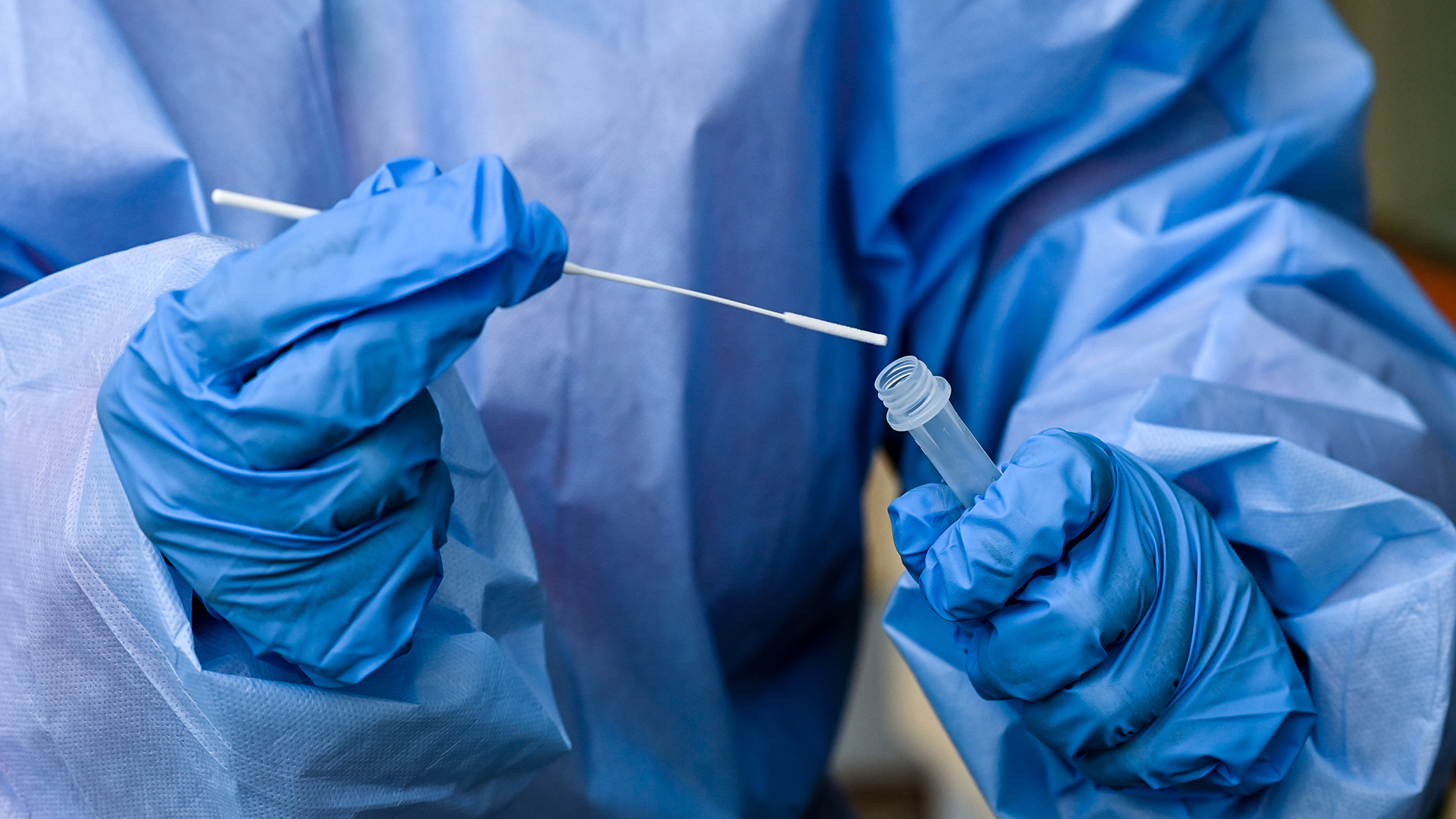  Eine Krankenschwester eines mobilen Test-Teams steckt während einer Corona-Testung ein Teststäbchen in die Flüssigkeit eines Schnelltests.