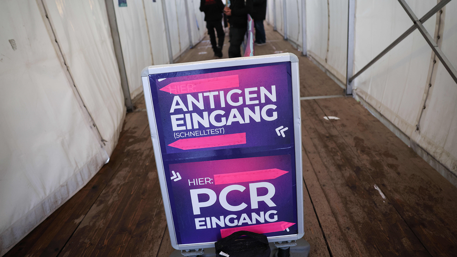 Ein Schild mit Hinweisen zum Corona-Schnelltests (Antigentest) und PCR-Test steht im Eingang zu einem Testcenter in Hamburg. | dpa