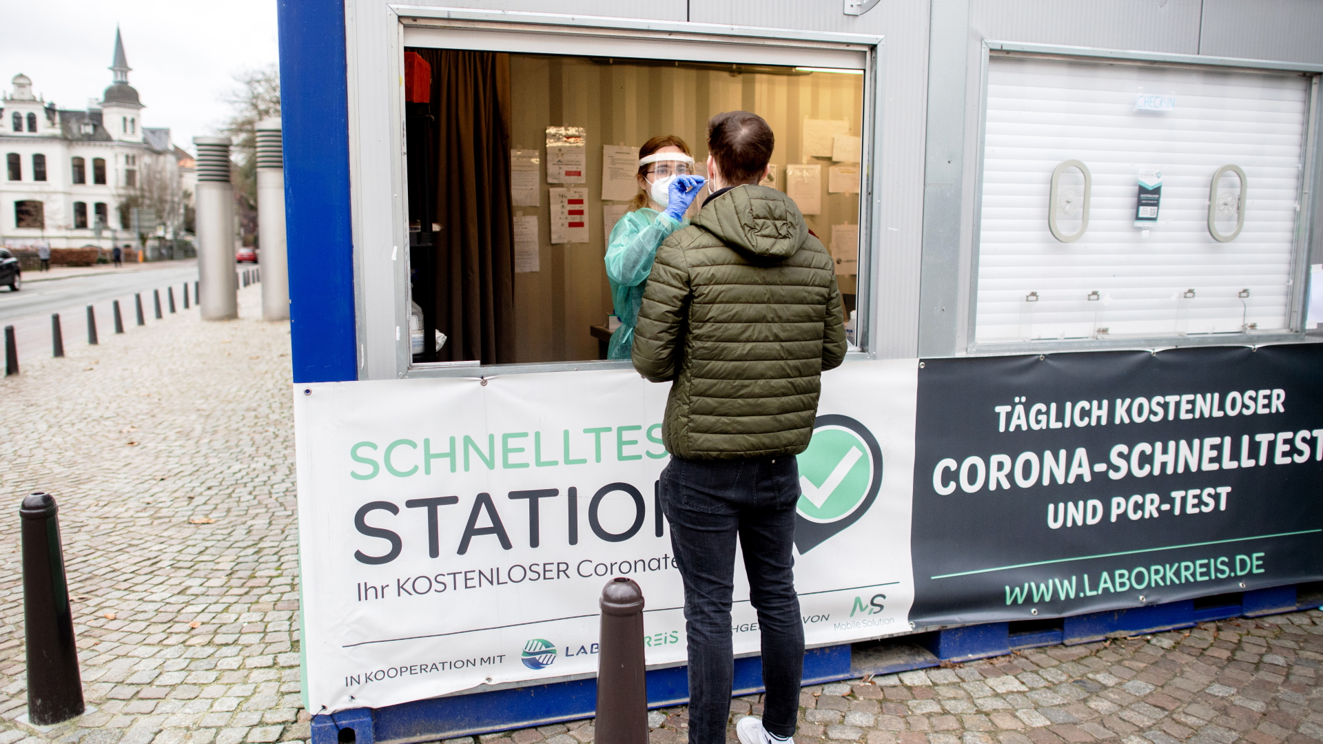 Eine Mitarbeiterin einer Teststation nimmt einen Corona-Abstrich eines Mann in Oldenburg, Niedersachen. | dpa