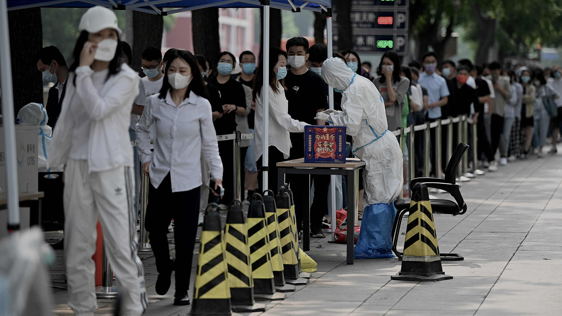 Menschen stehen in Peking (China) Schlange vor einer Teststation zur Untersuchung auf das Coronavirus. | AFP