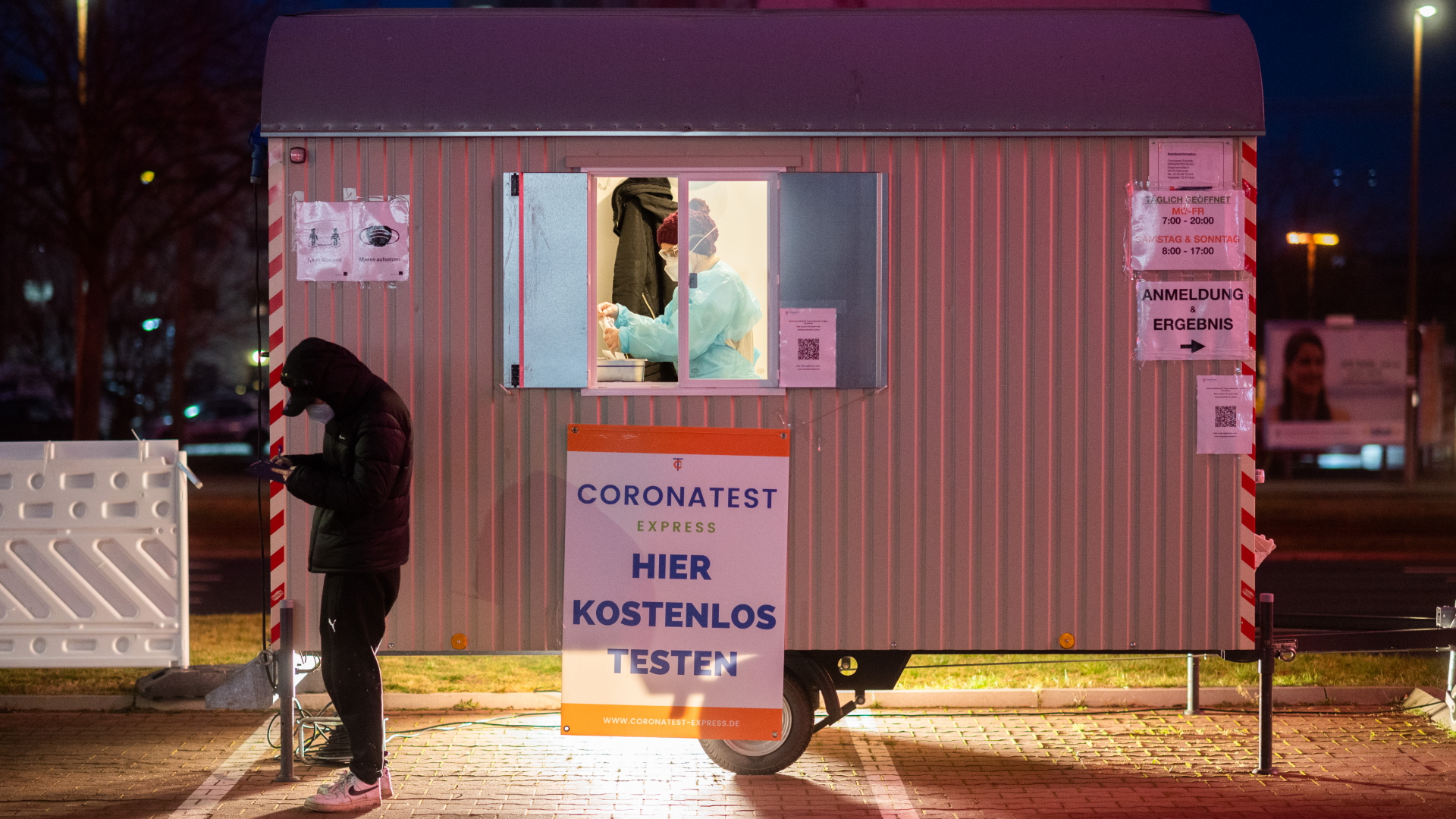 Ein Mann steht vor einem mobilen Corona-Testzentrum auf einem Parkplatz in Laatzen, Niedersachsen. | dpa
