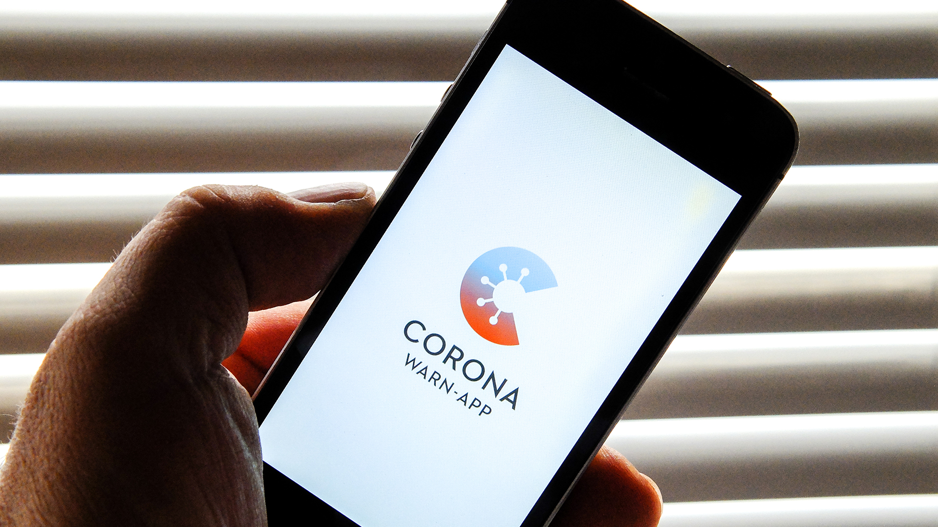 Auf dem Bildschirm eines Smartphones ist der Startschirm der Corona-Warn-App abgebildet.