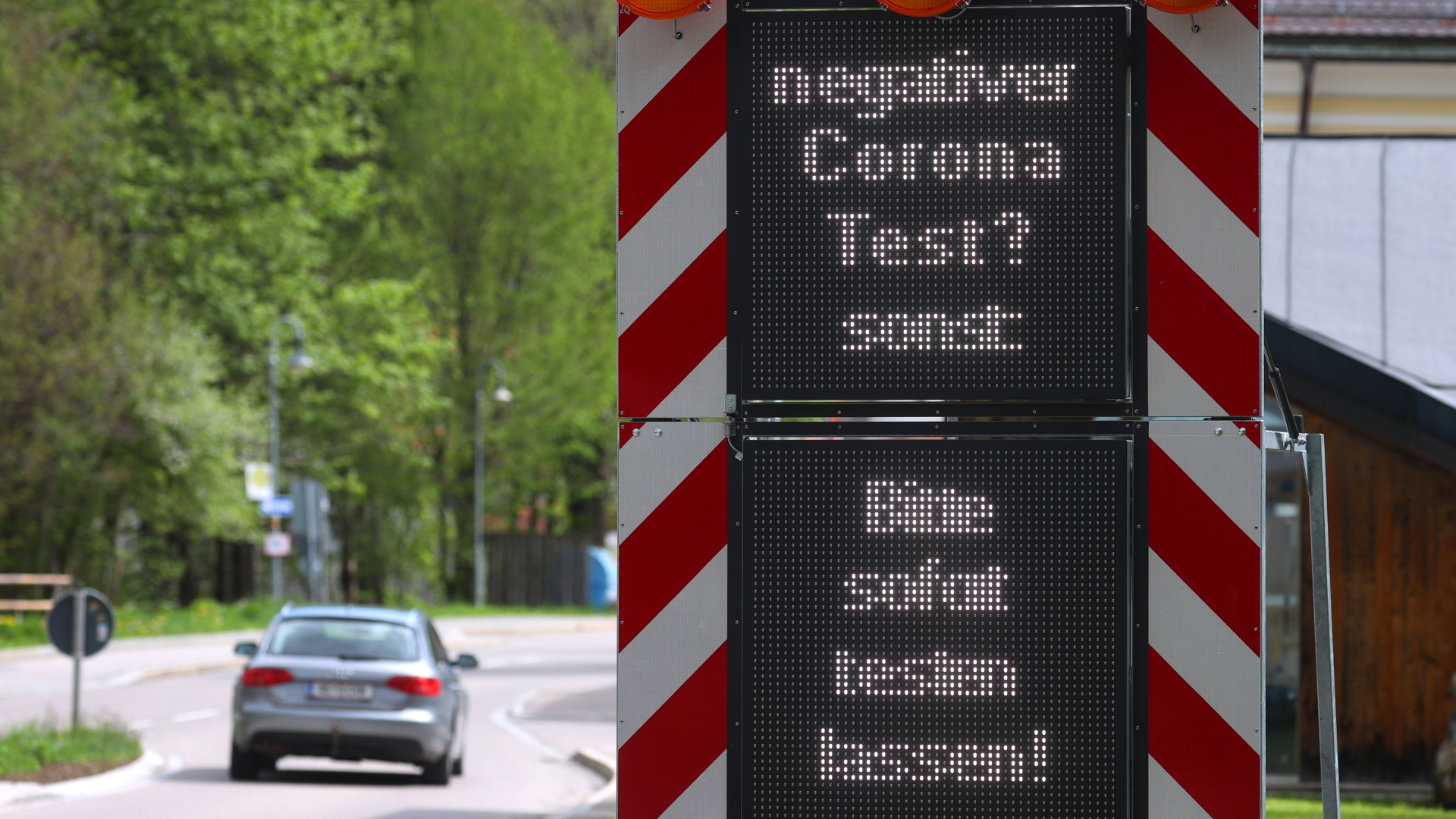 Auf einem Warnschild an der österreichisch-deutschen Grenze wird um einen Coronatest gebeten. | dpa