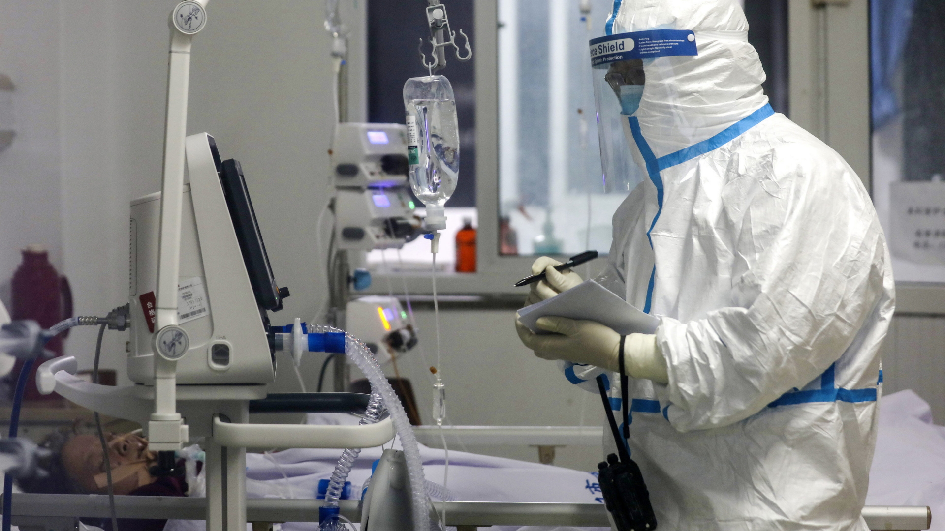Ein Krankenhausmitarbeiter im Schutzanzug kümmert sich um einen Coronavirus-Patienten. | AP